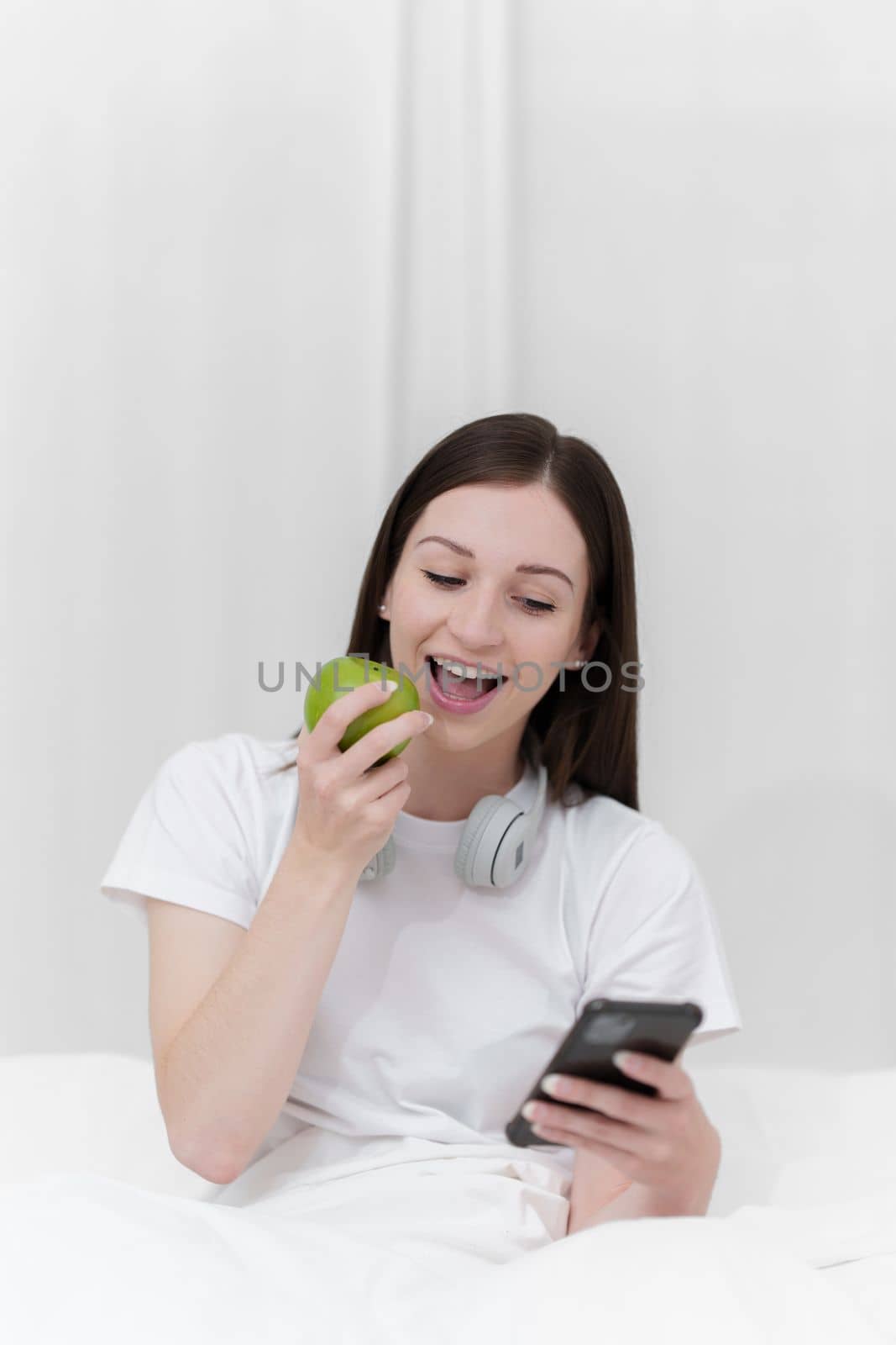 Portrait of Good Healthy woman eating green apple and resting in bed at bedroom. Lifestyle at home concept