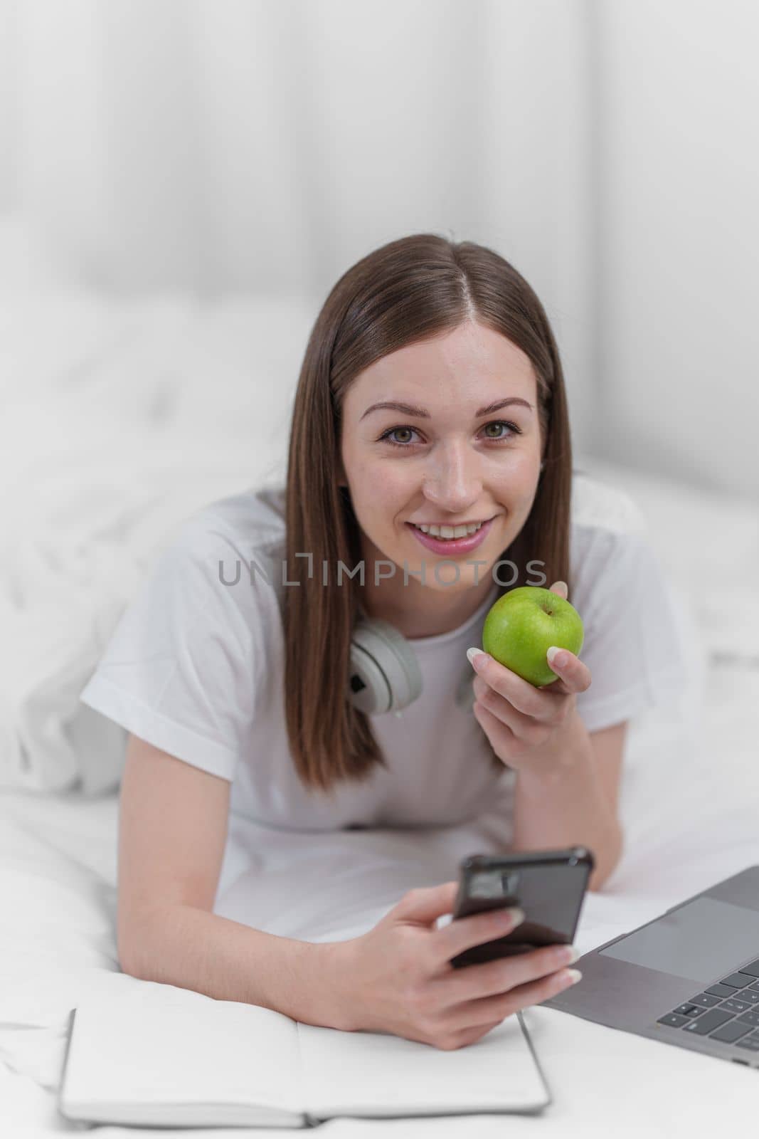 Portrait of Good Healthy woman eating green apple and resting in bed at bedroom. Lifestyle at home concept. by itchaznong