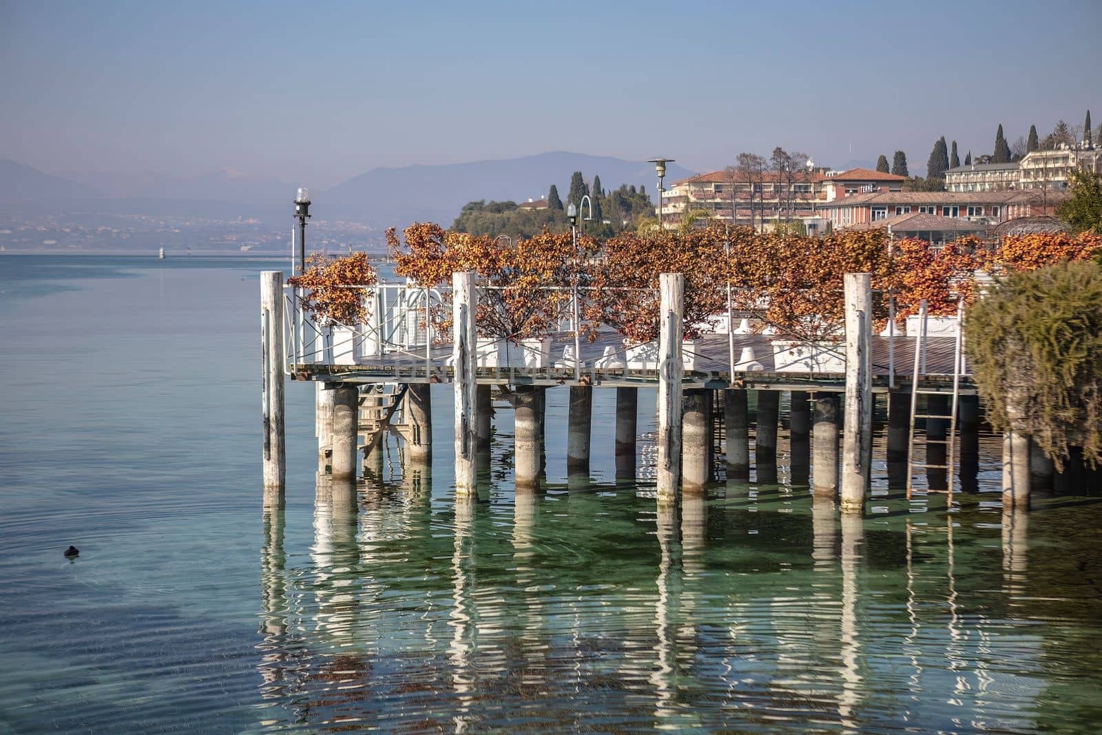 The beautiful landscape of Sirmione on the Garda Lake Riviera, with its crystal clear waters and stunning mountains in the distance.