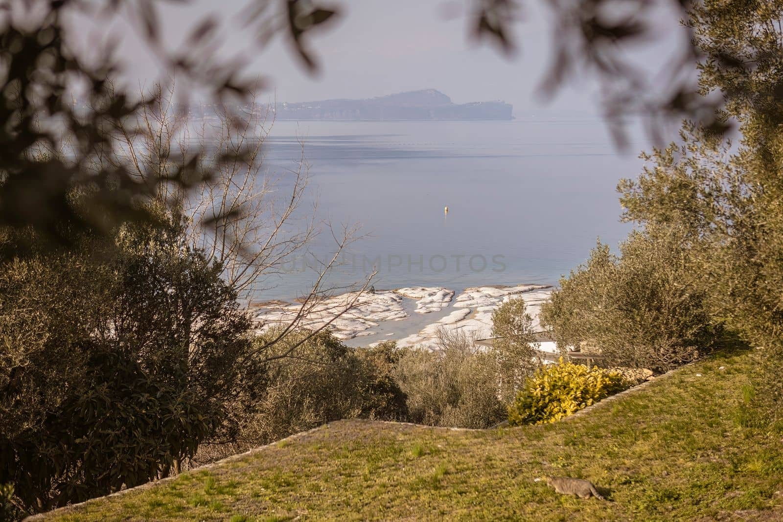 Aerial view of natural beach in Sirmione, overlooking the rocky shores of Lake Garda by pippocarlot