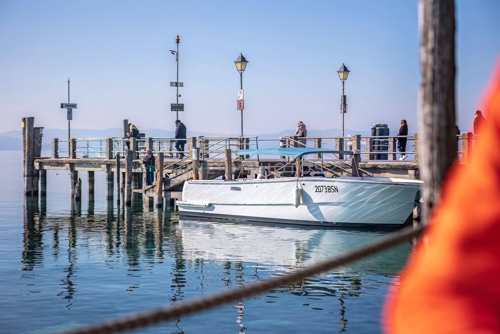 Serene scene in Sirmione Marina with Boats Moored at the Pier by pippocarlot