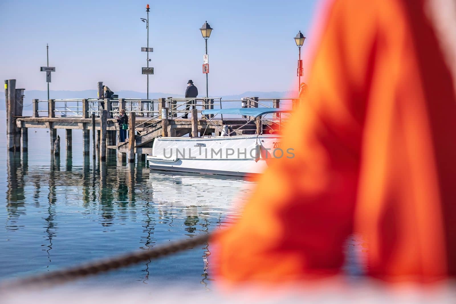 Serene scene in Sirmione Marina with Boats Moored at the Pier by pippocarlot