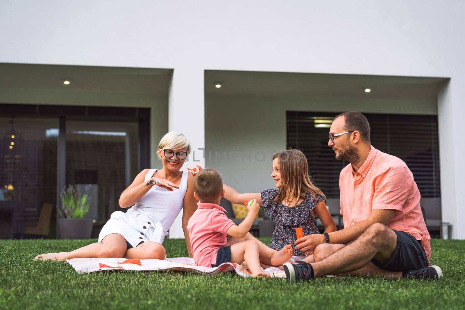 Family picnic on a sunny summer day, their house in the background by VisualProductions