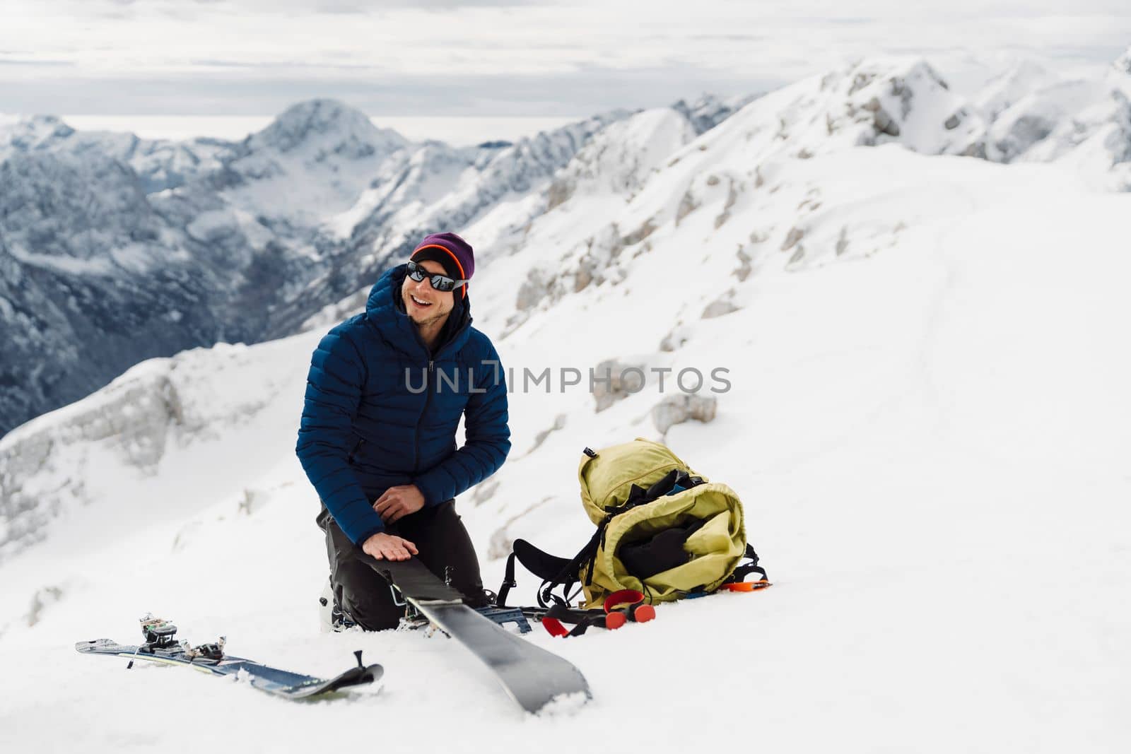 Mountaineer backcountry ski touring in the mountains. Ski touring in high alpine landscape with snowy trees. Adventure winter extreme sport. High quality photo