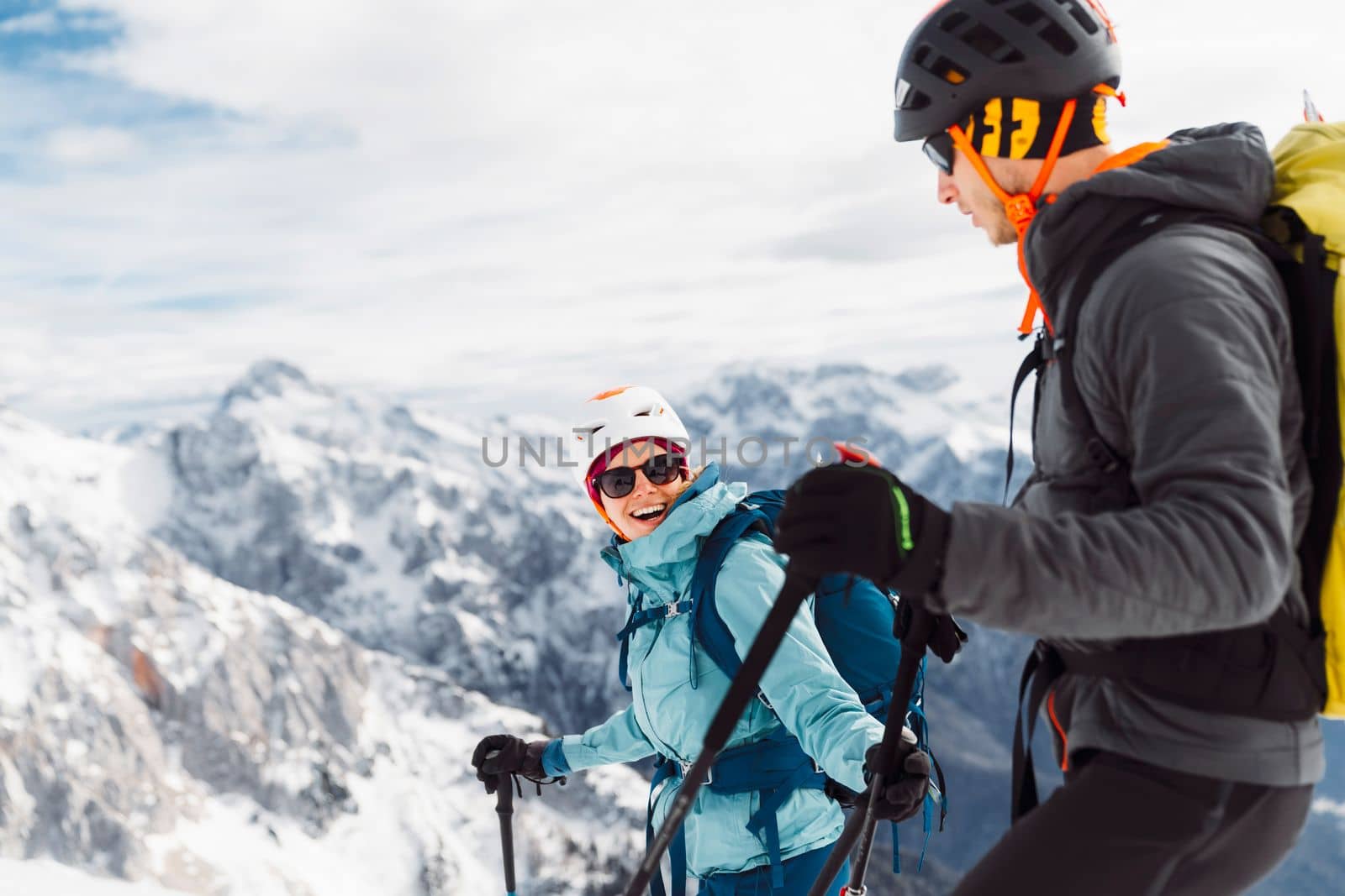 Waist up smiling couple of mountaineers ski touring in the snowy Alps by VisualProductions