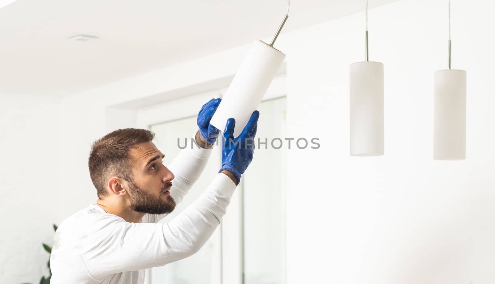 Home Ceiling Light Equipment Maintenance. Professional Electrician Worker
