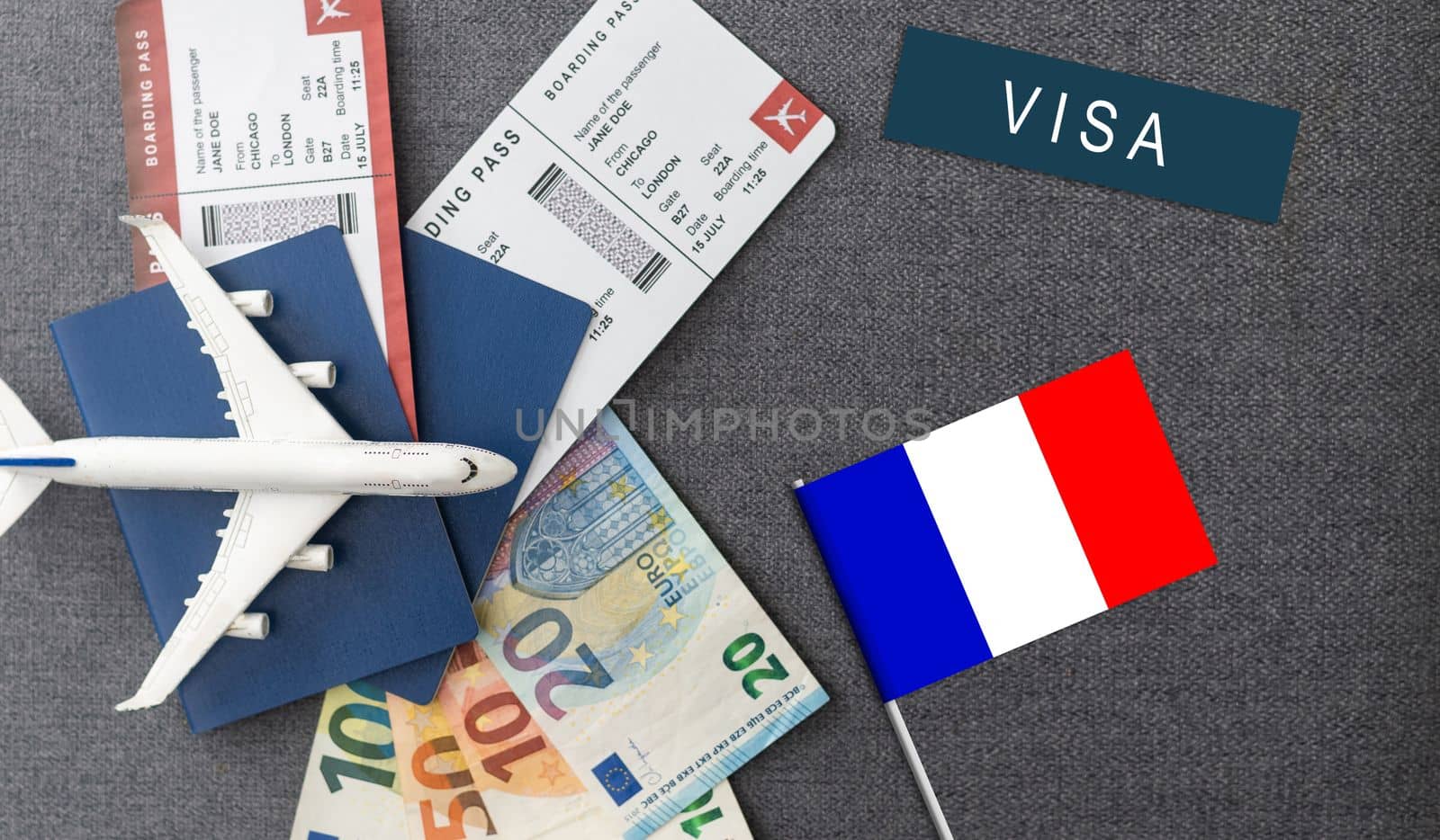 Flag of France with passport and toy airplane on wooden background. Flight travel concept.