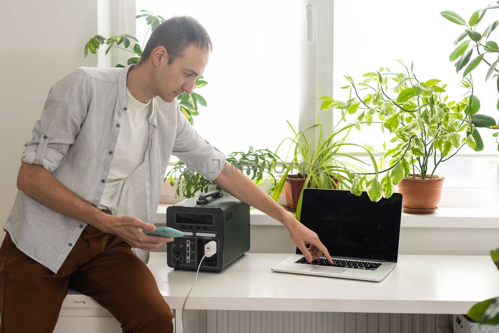 a man uses a portable charging station by Andelov13