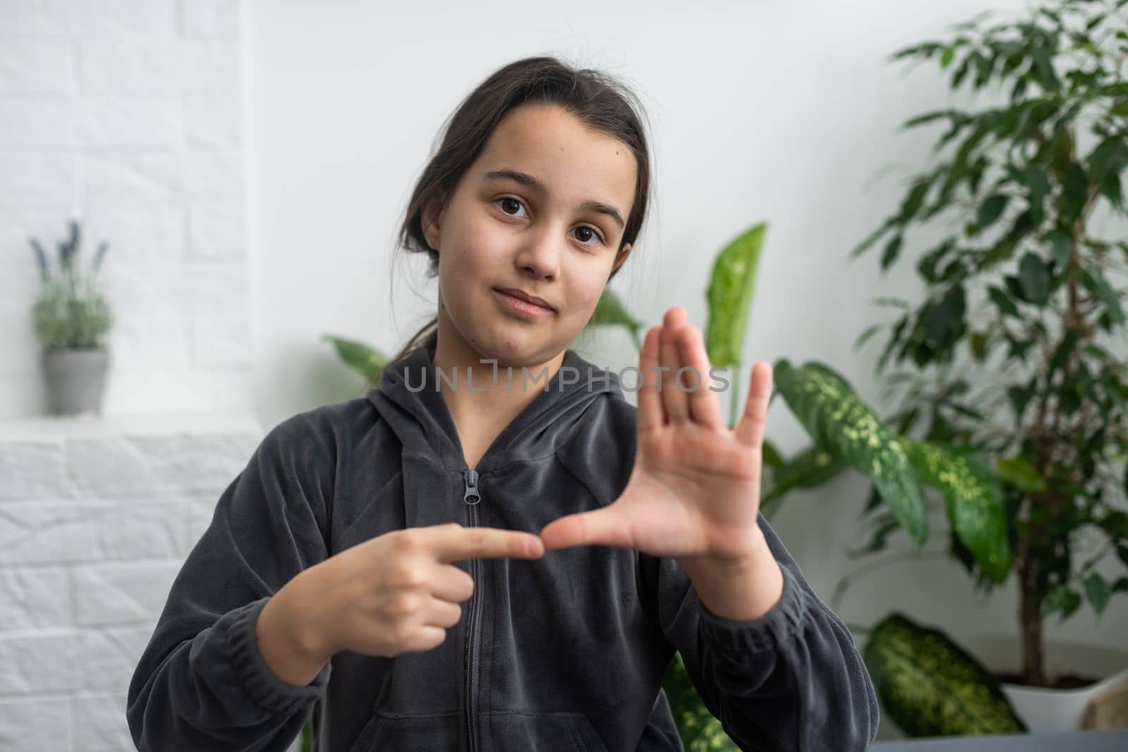 A smiley teenage girl hand sign.