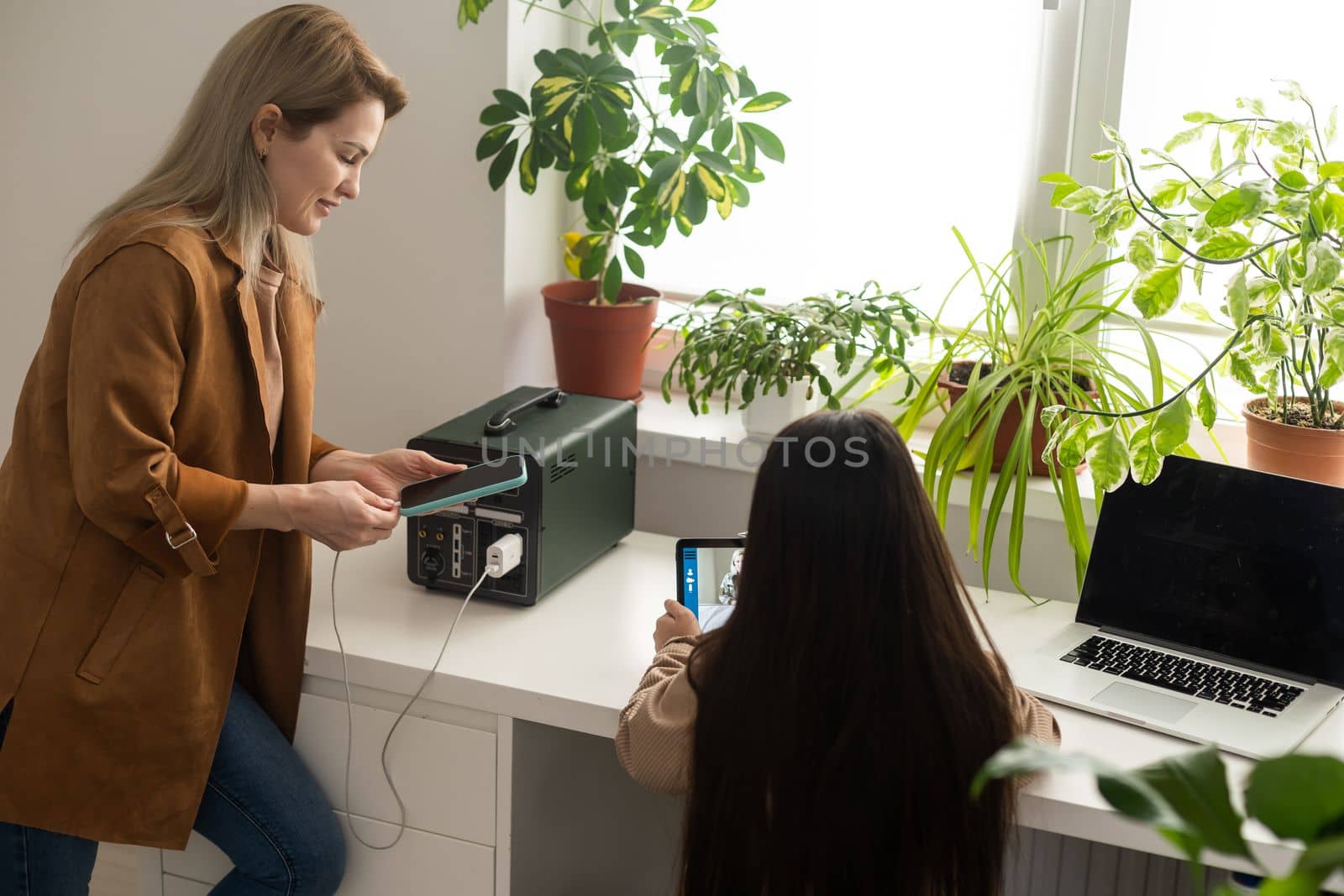 mother and daughter use a portable charging station.