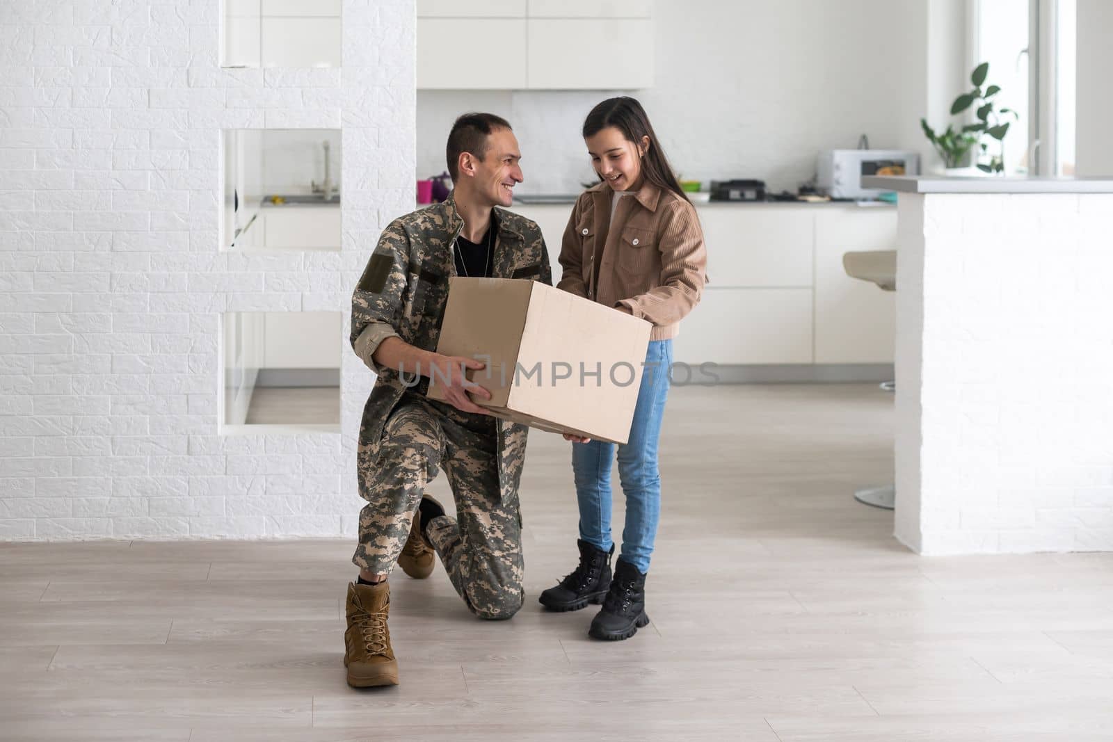 Happy military serviceman holding cardboard box with girl by Andelov13