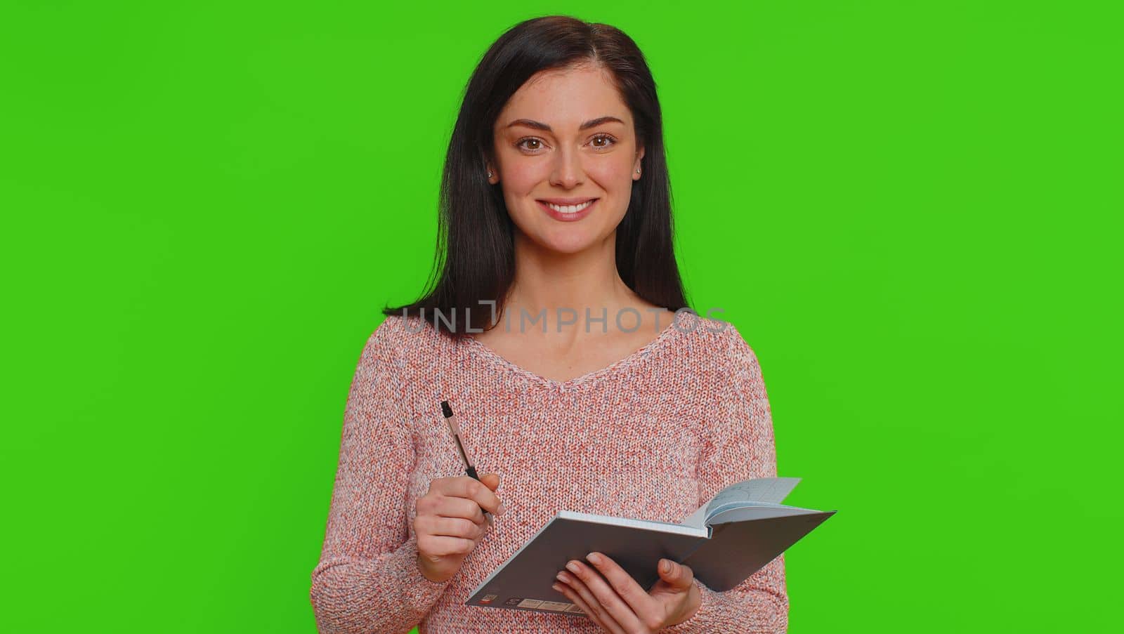 Thoughtful journalist woman making notes, writing down thoughts with pen into notepad notebook diary by efuror