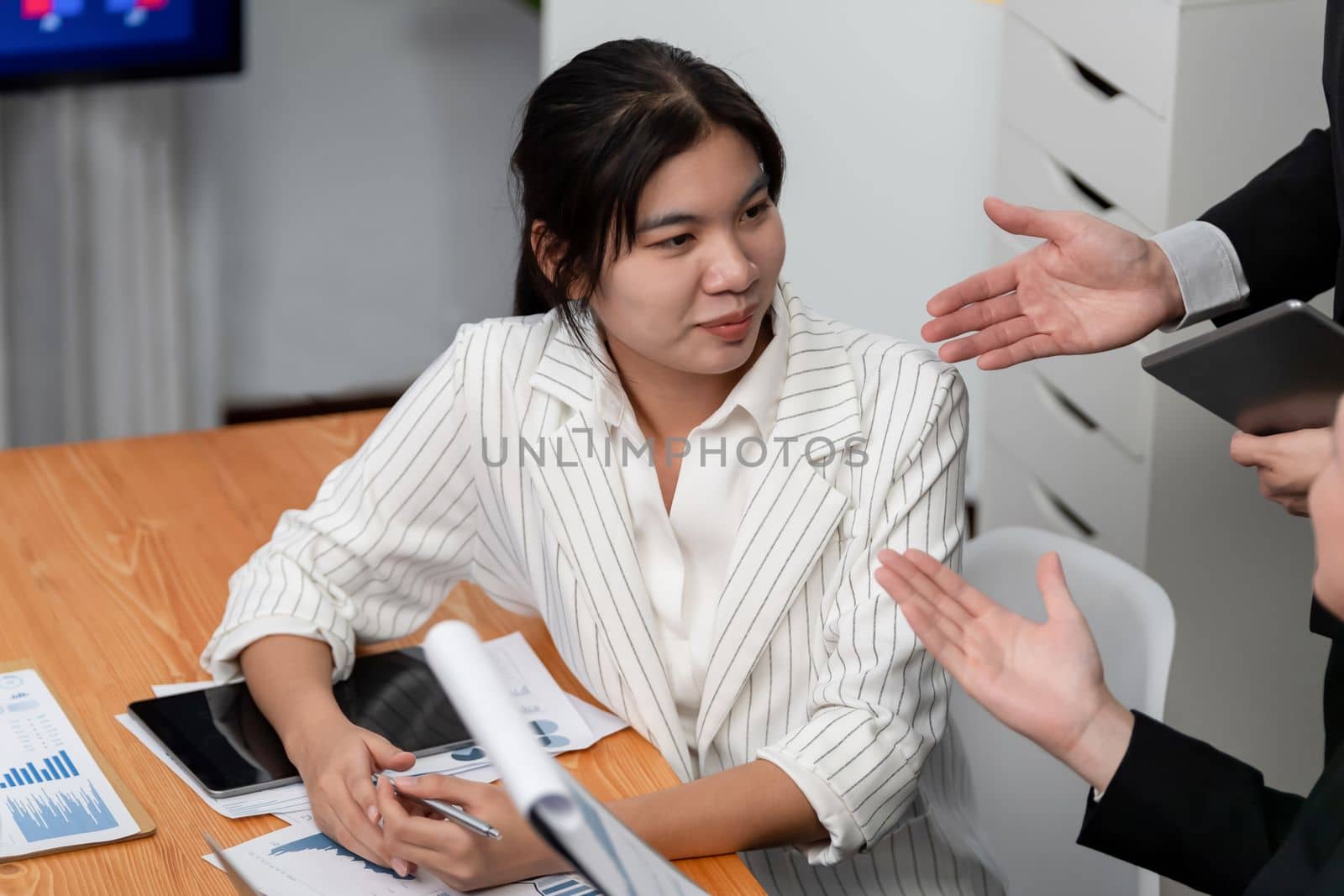 Harmony in office concept as business people analyzing dashboard paper together in workplace. Young colleagues give ideas at manager desk for discussion or strategy planning about project.