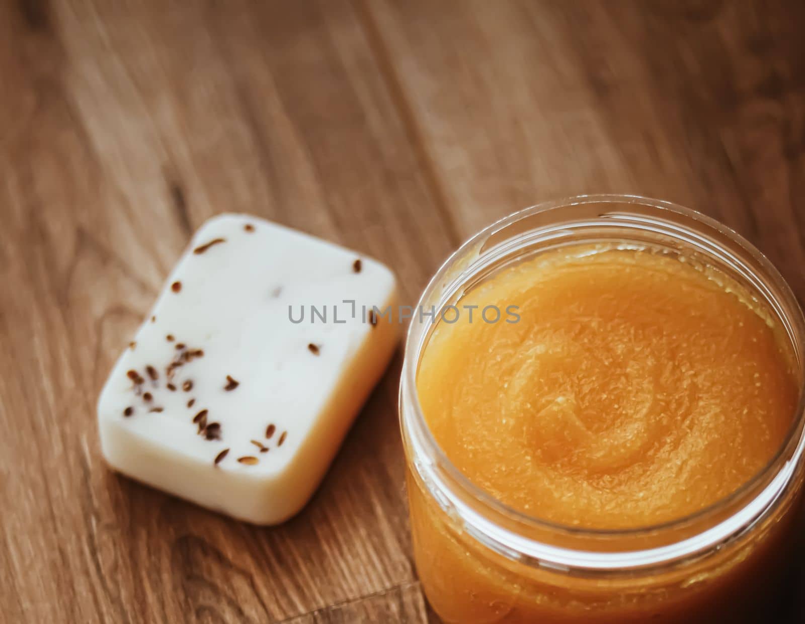 Citrus and honey orange body scrub jar on rustic wood background, beauty cosmetic and skincare product.