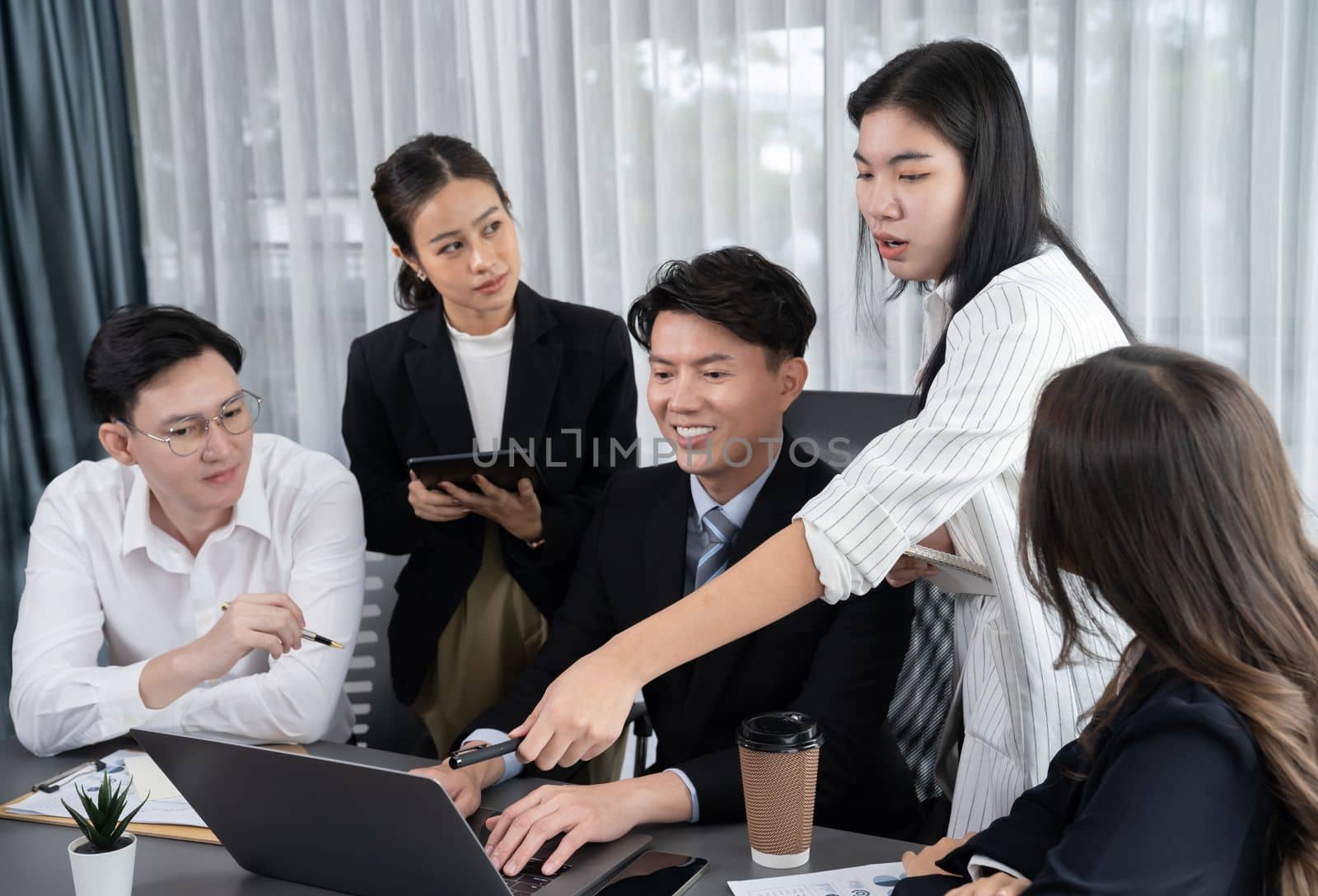 Harmony in office concept as business people analyzing dashboard paper together in workplace. Young colleagues give ideas at manager desk for discussion or strategy planning about project.