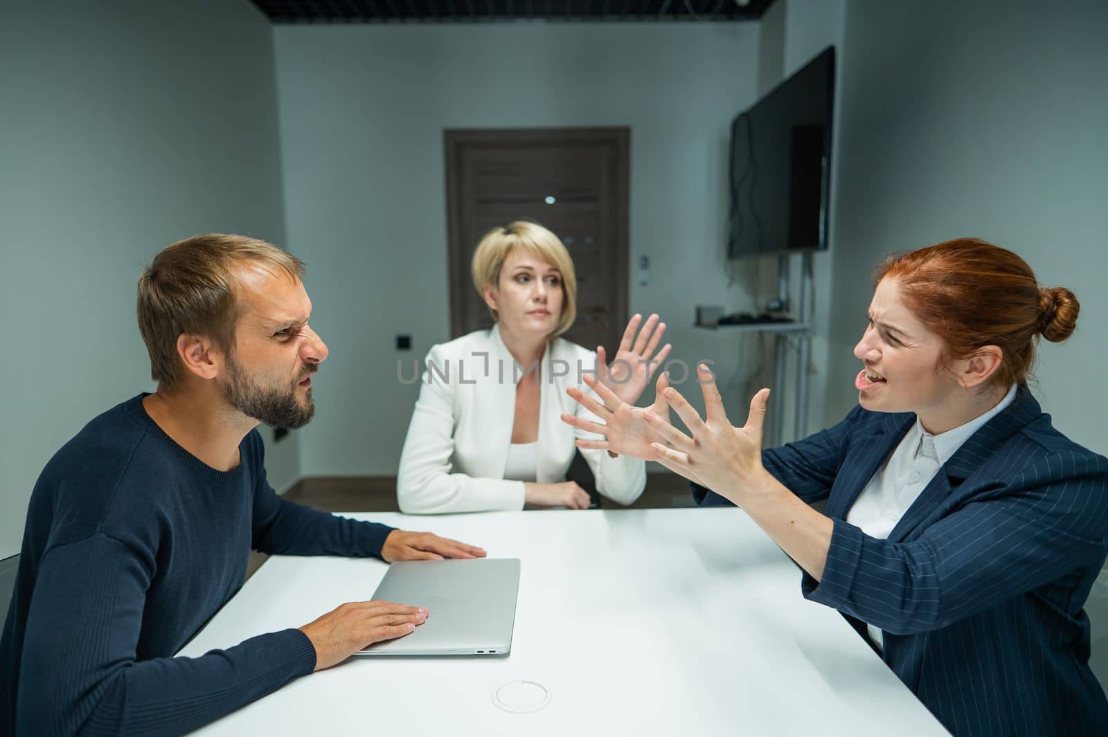 Blond, red-haired woman and bearded man in suits in the office. Business people are swearing during negotiations in the conference room