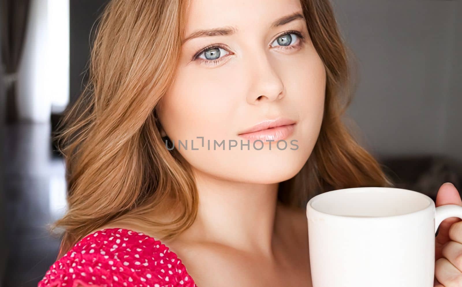 Beautiful woman having a cup of tea in the morning at home by Anneleven