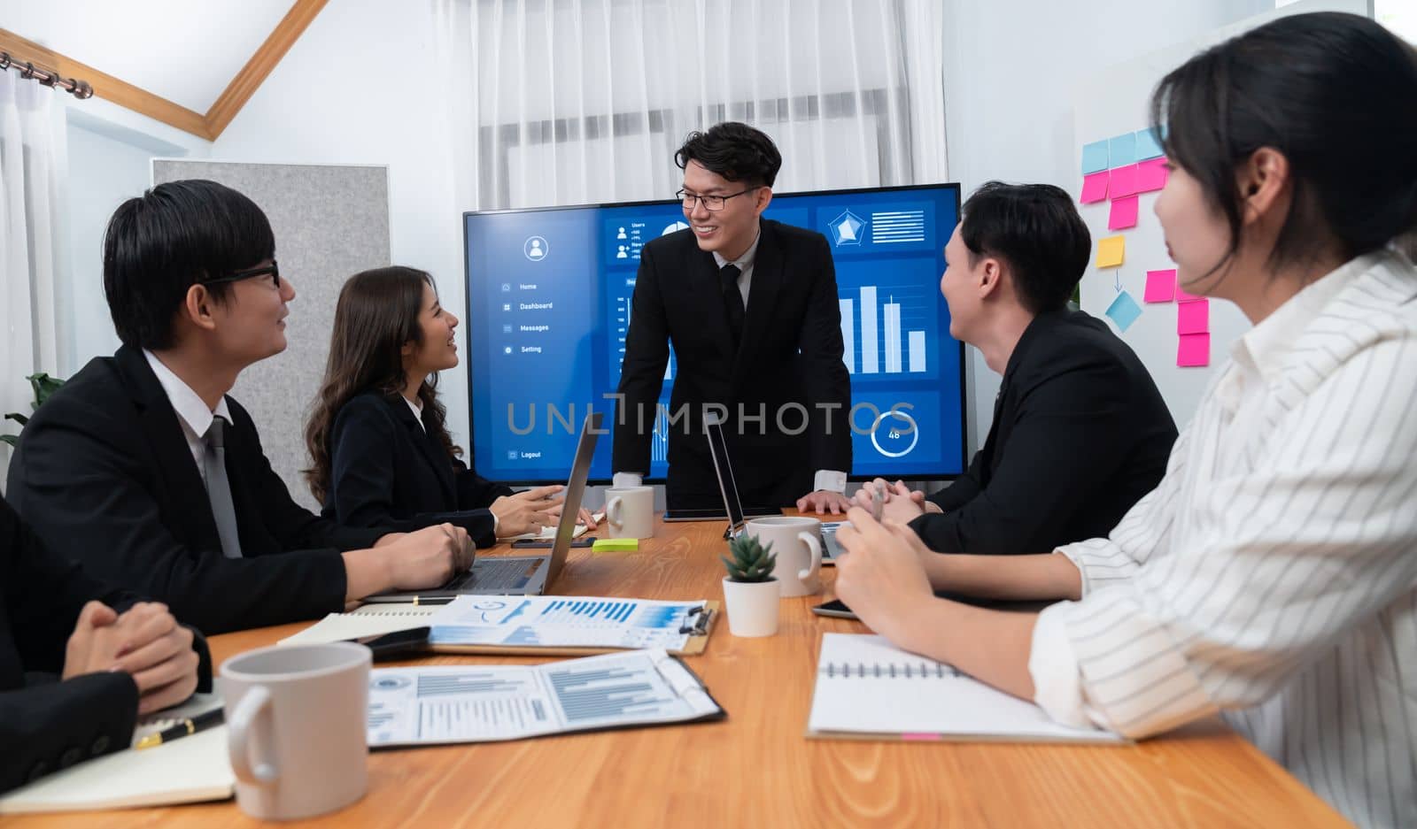 Confidence and asian businessman give presentation on financial analyzed by business intelligence in dashboard report to other people in board room meeting to promote harmony in workplace.