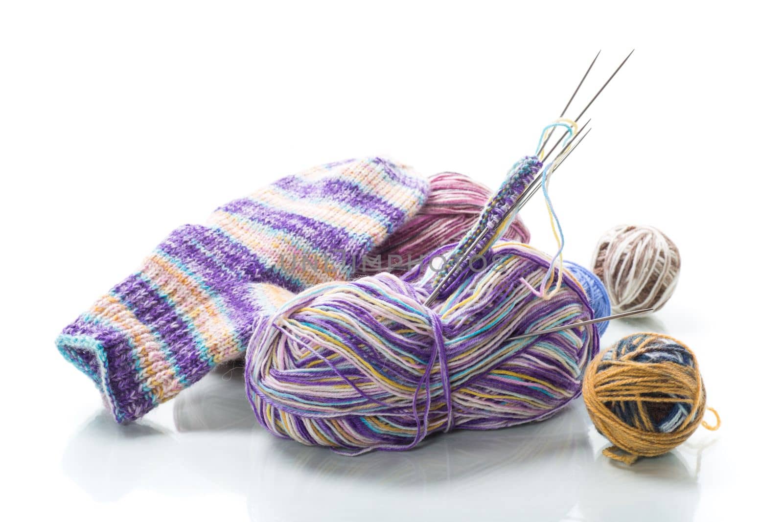 Colored threads, knitting needles and other items for hand knitting, isolated on a white background.