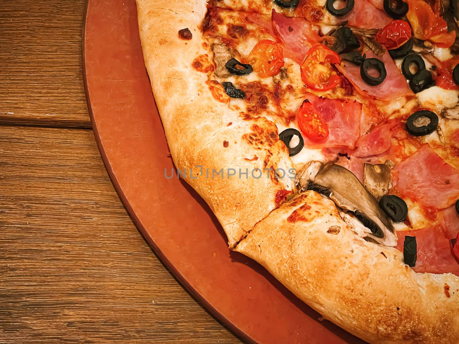 Pizza capriciosa with cheese stuffed crust in pizzeria, food close-up