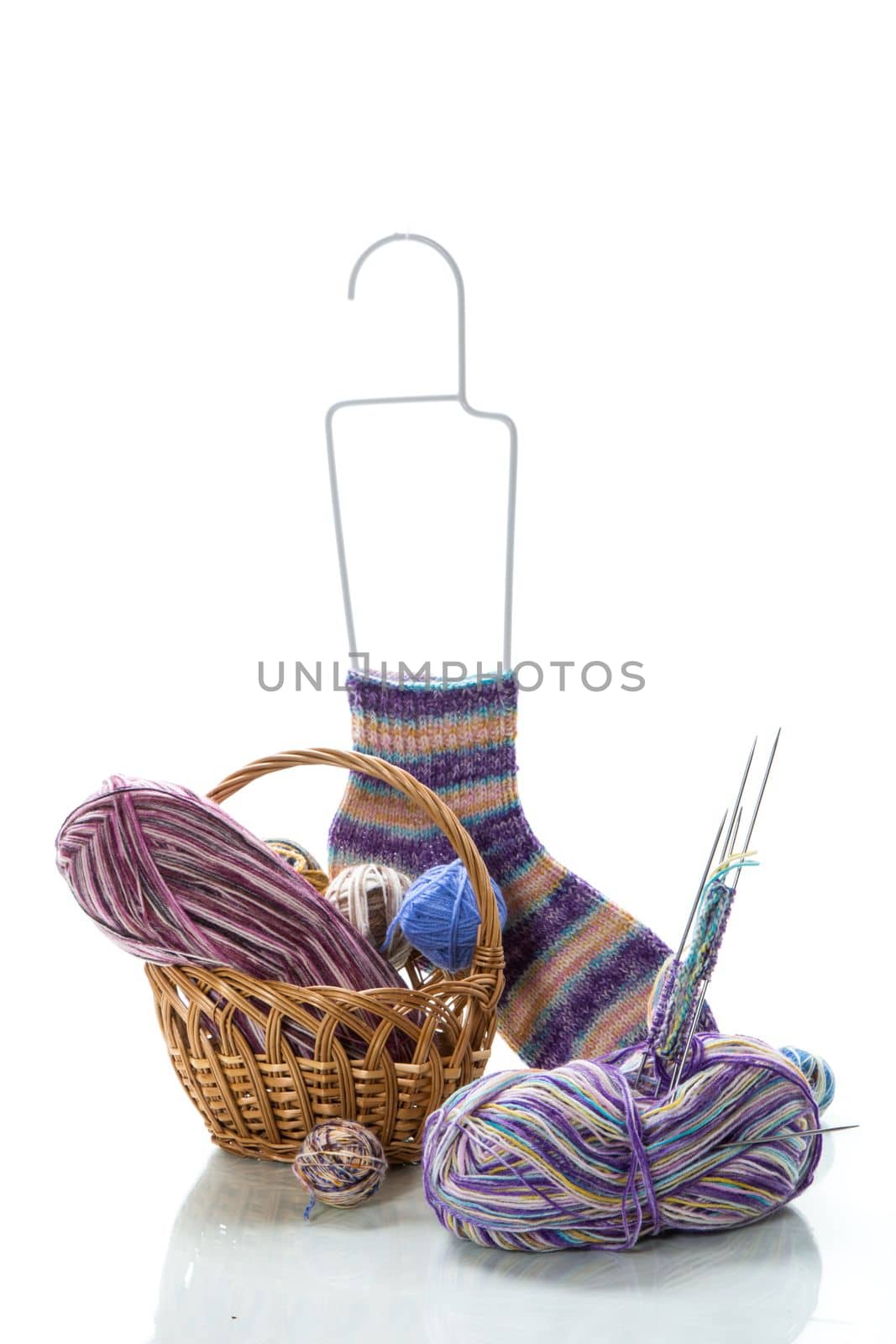 Colored threads, knitting needles and other items for hand knitting, isolated on a white background.