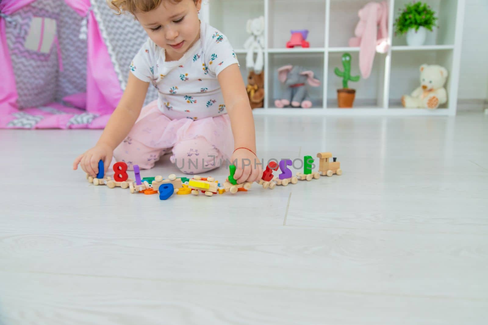 A child plays with a train made of numbers. Selective focus. Kid.