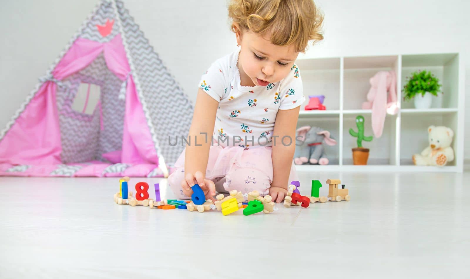 A child plays with a train made of numbers. Selective focus. Kid.