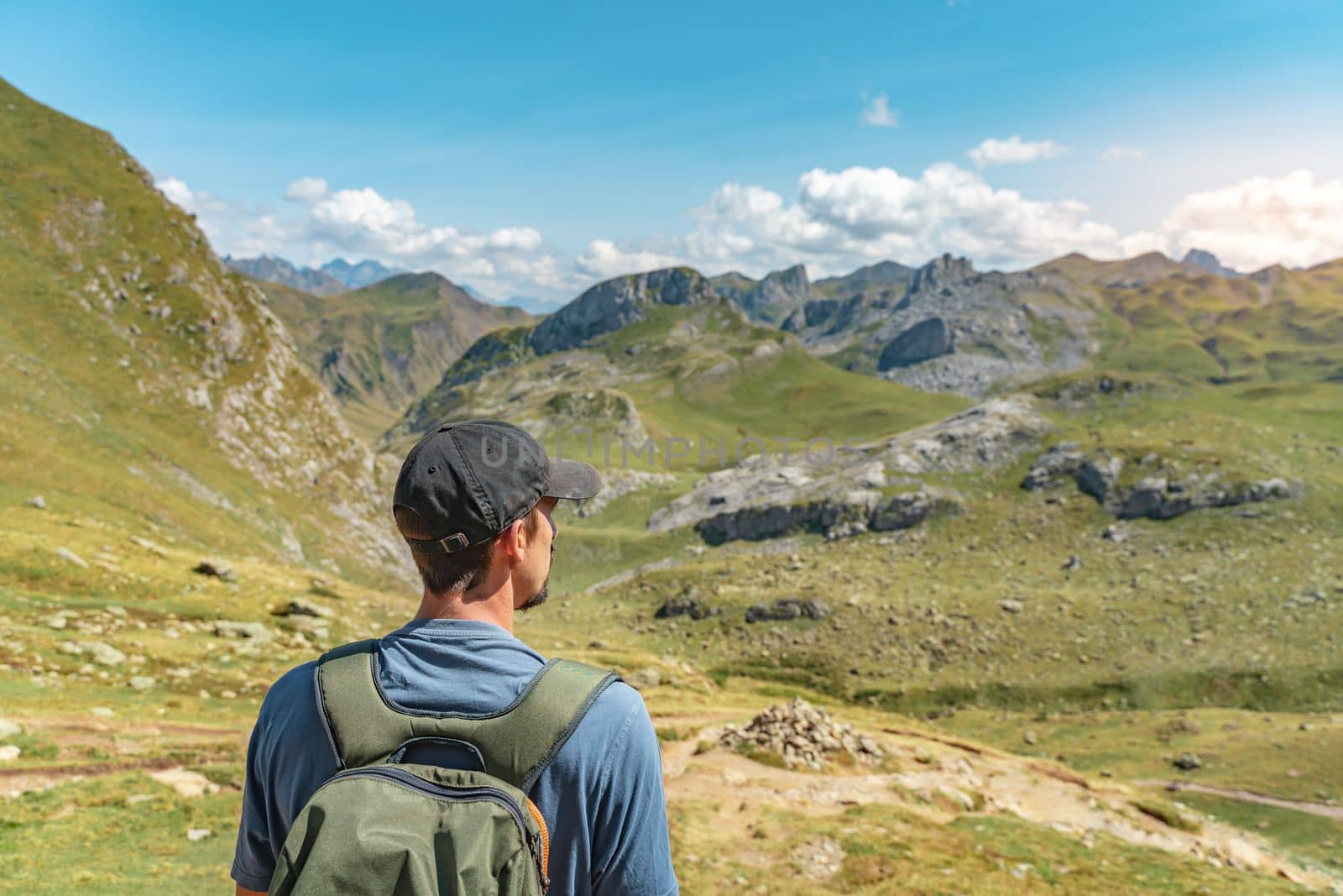 Young Attractive Man With A Backpack hiking in a beautiful valley between mountains during the sunset. Discovery Travel Destination Concept by PaulCarr