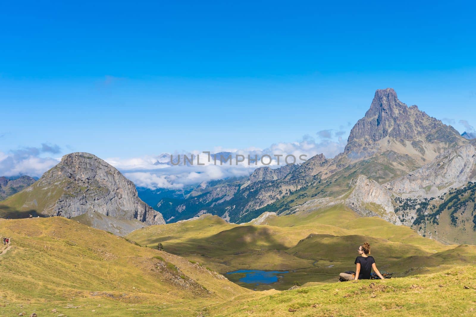 Young Attractive Woman sitting resting in a Beautiful wild mountain Landscape in summer. Discovery Travel Destination Concept. High quality photo