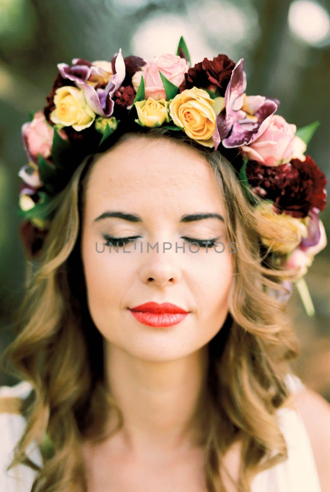 Bride in a colorful wreath of roses and orchids. Portrait. High quality photo