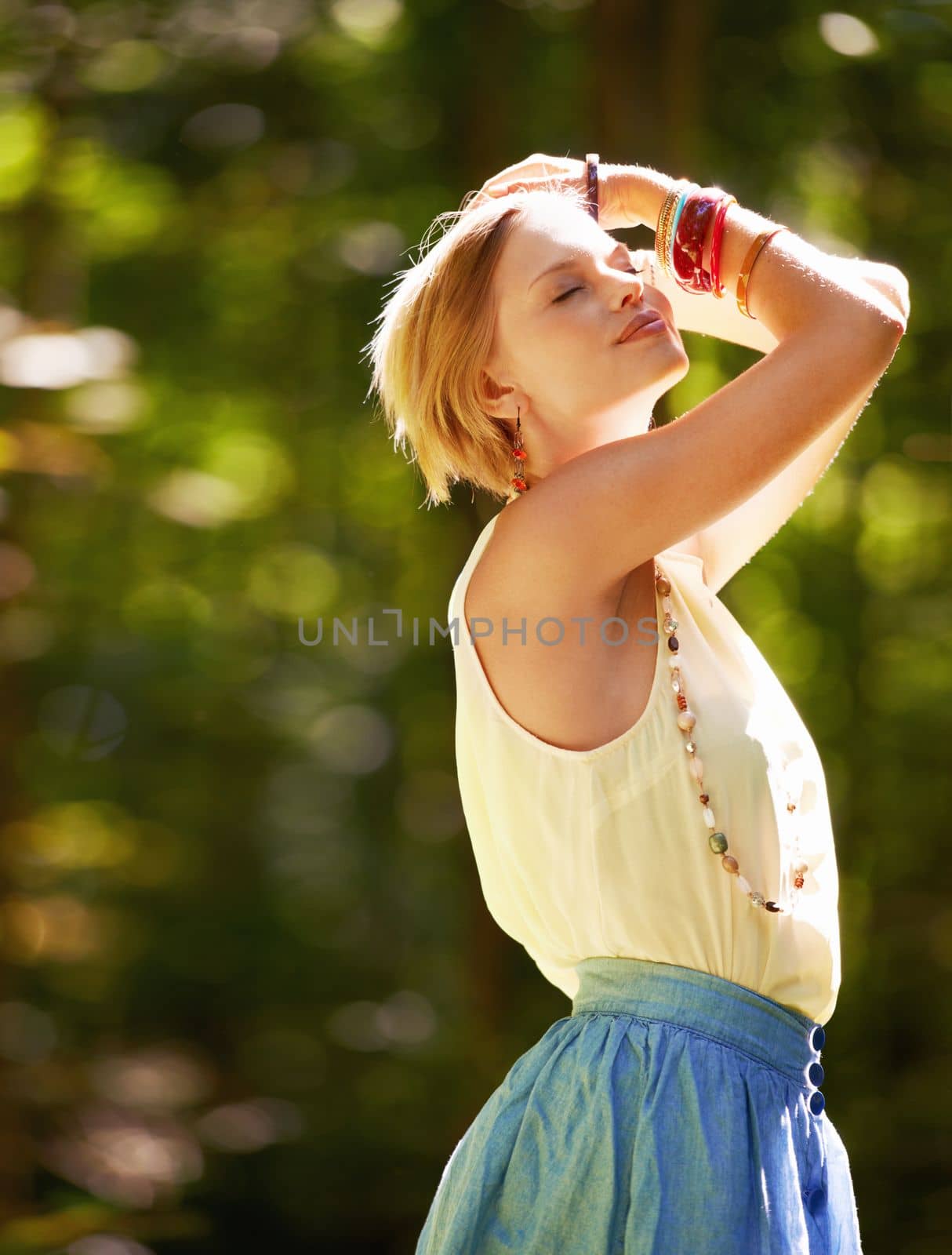 Fascinated by nature. an attractive young woman outdoors on a summer day. by YuriArcurs