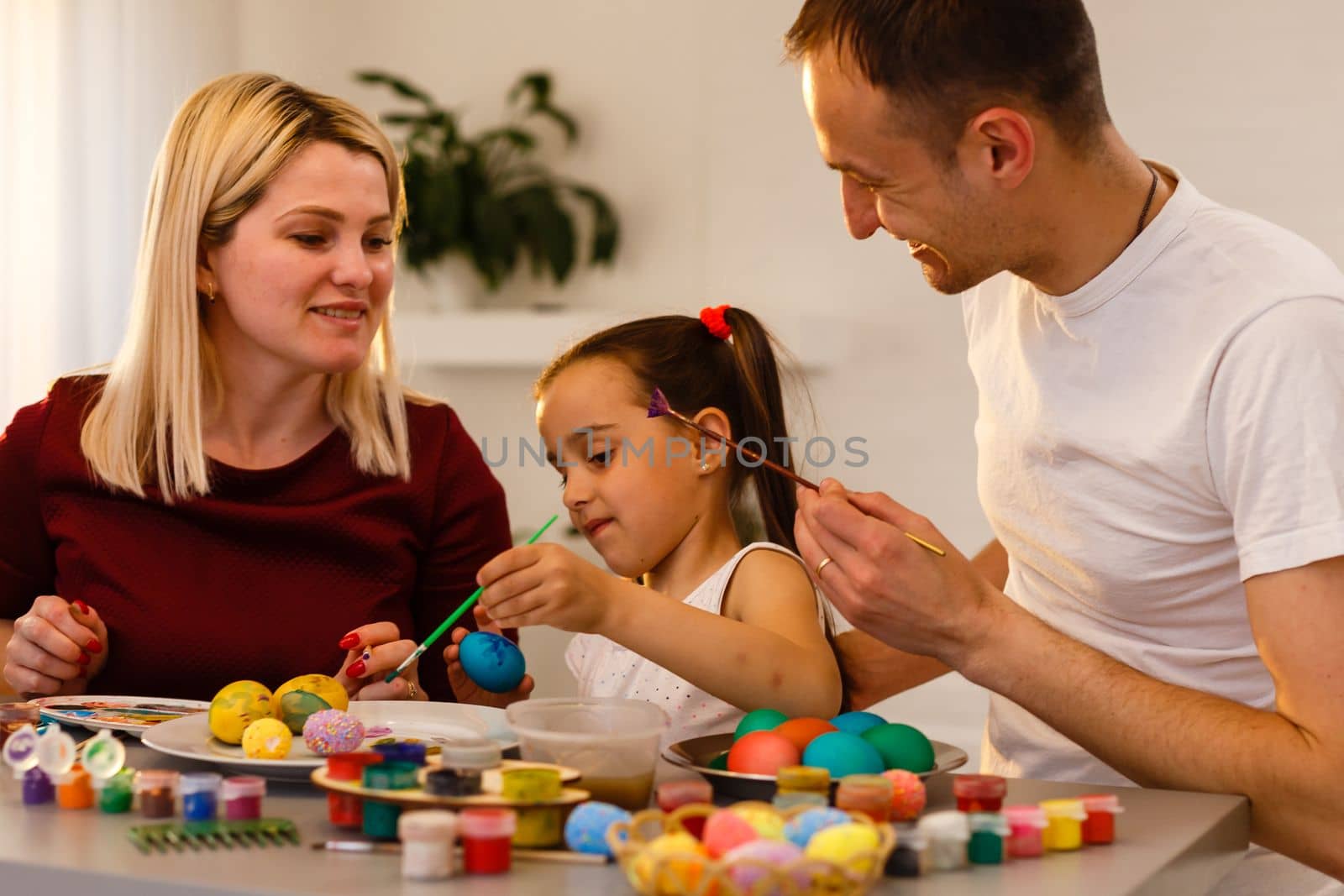 Easter Family traditions. family paint eggs at kitchen table.