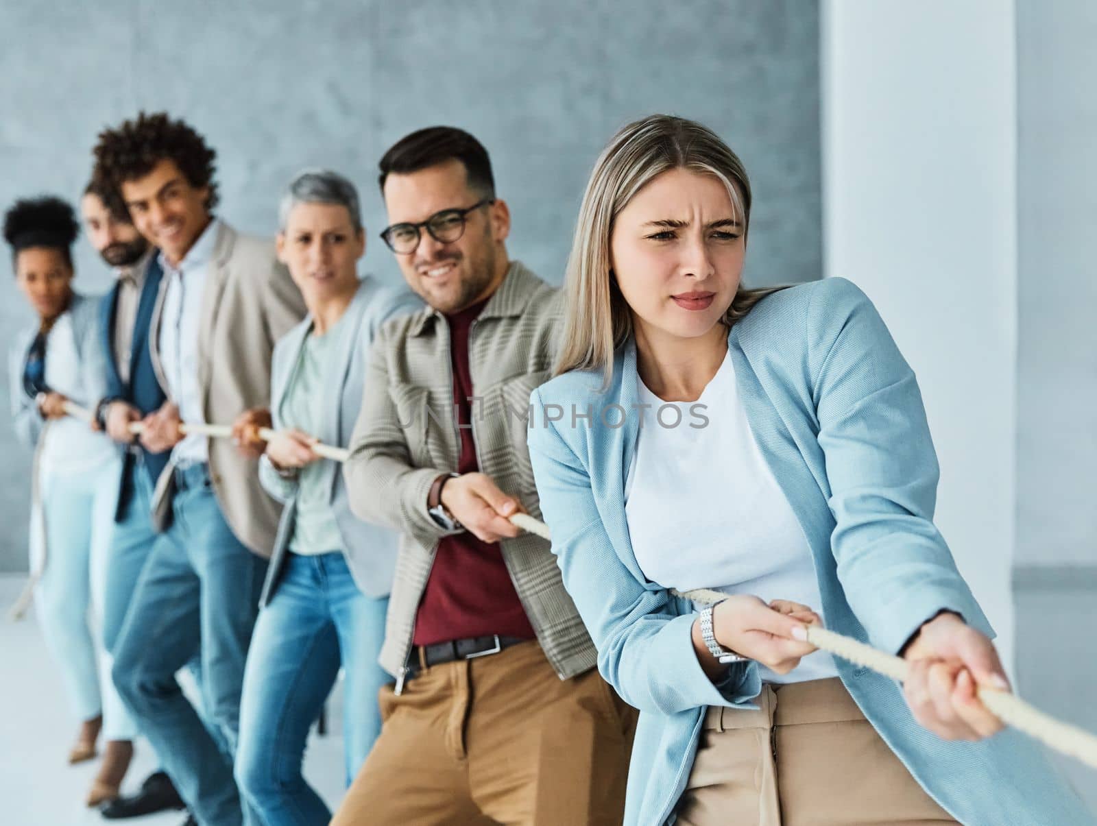 Portrait of a young businesspeople pulling a rope in the office