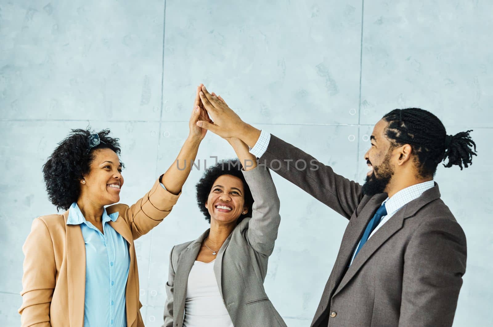Group of young african american business people having a meeting exchanging high five gesture introducing each other in the office. Teamwork and success concept