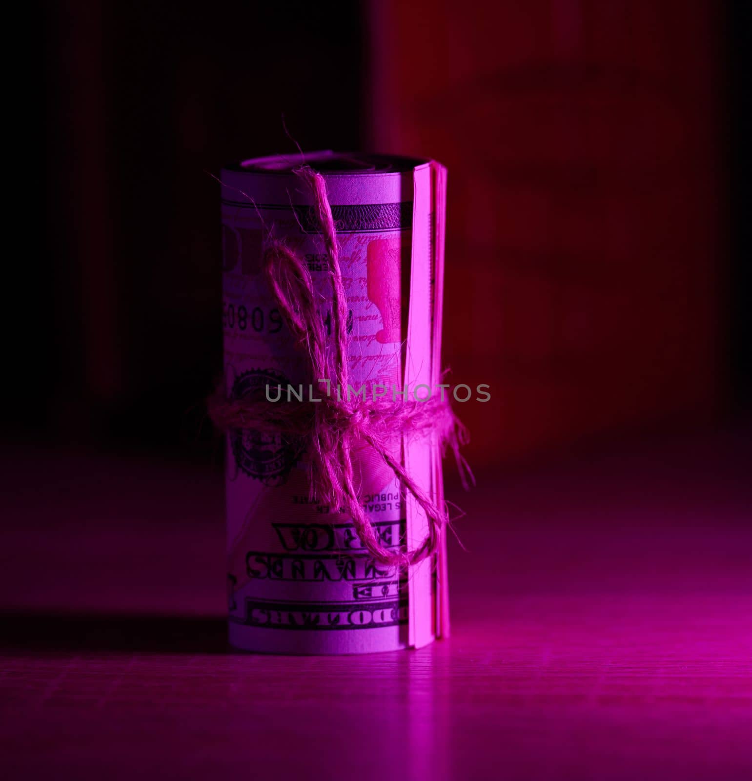 A roll of one hundred dollar bills tied with a rope. Income growth concept, high margin, profitable business