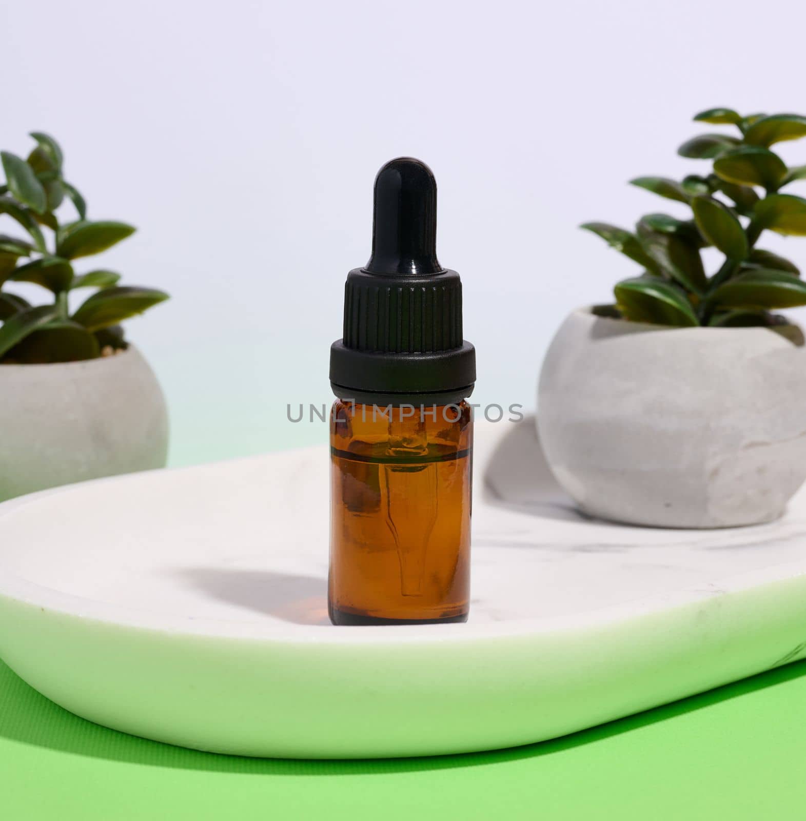 Brown glass bottle with pipette on a white background