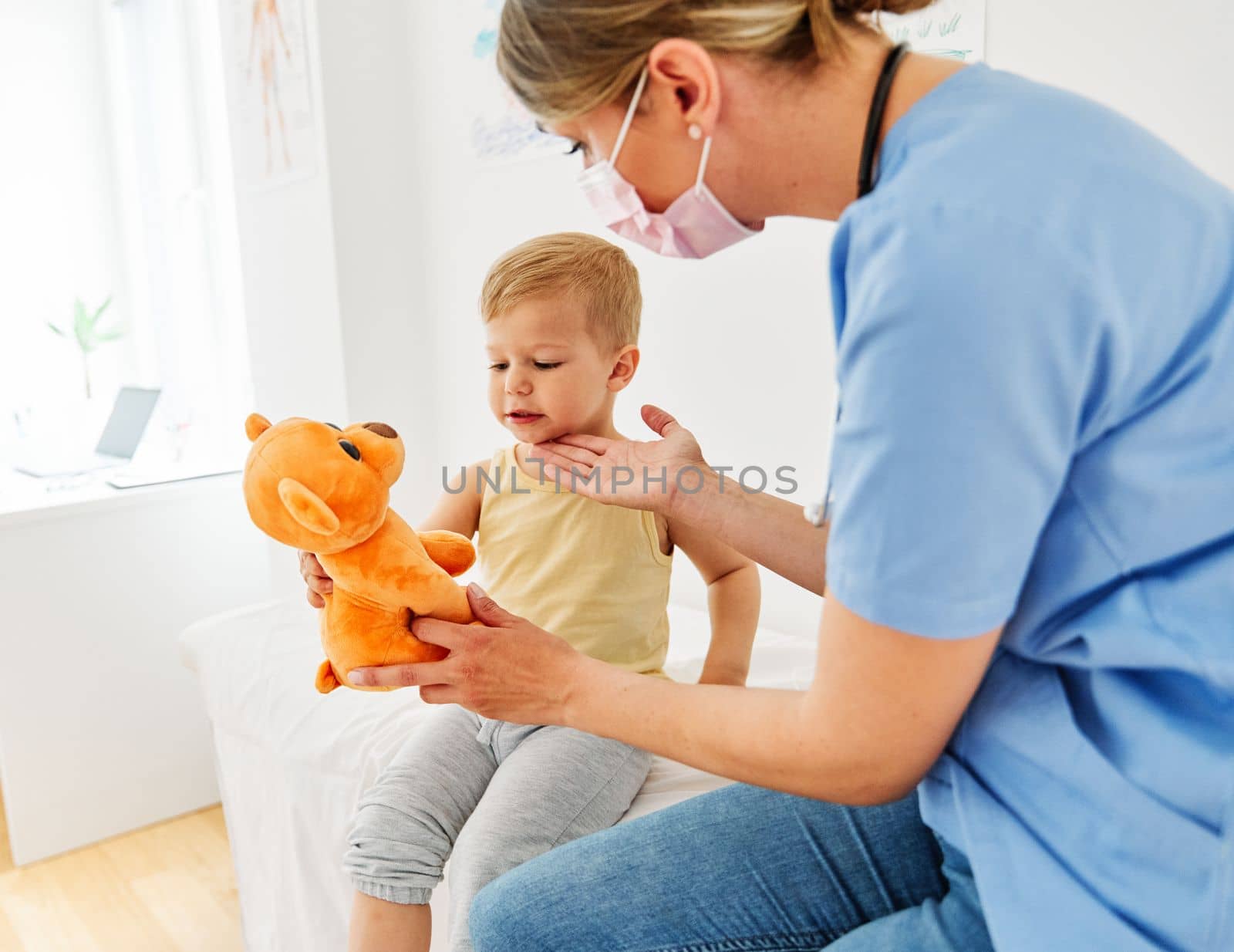 Female doctor or nurse with a little boy in doctor's office in clinic