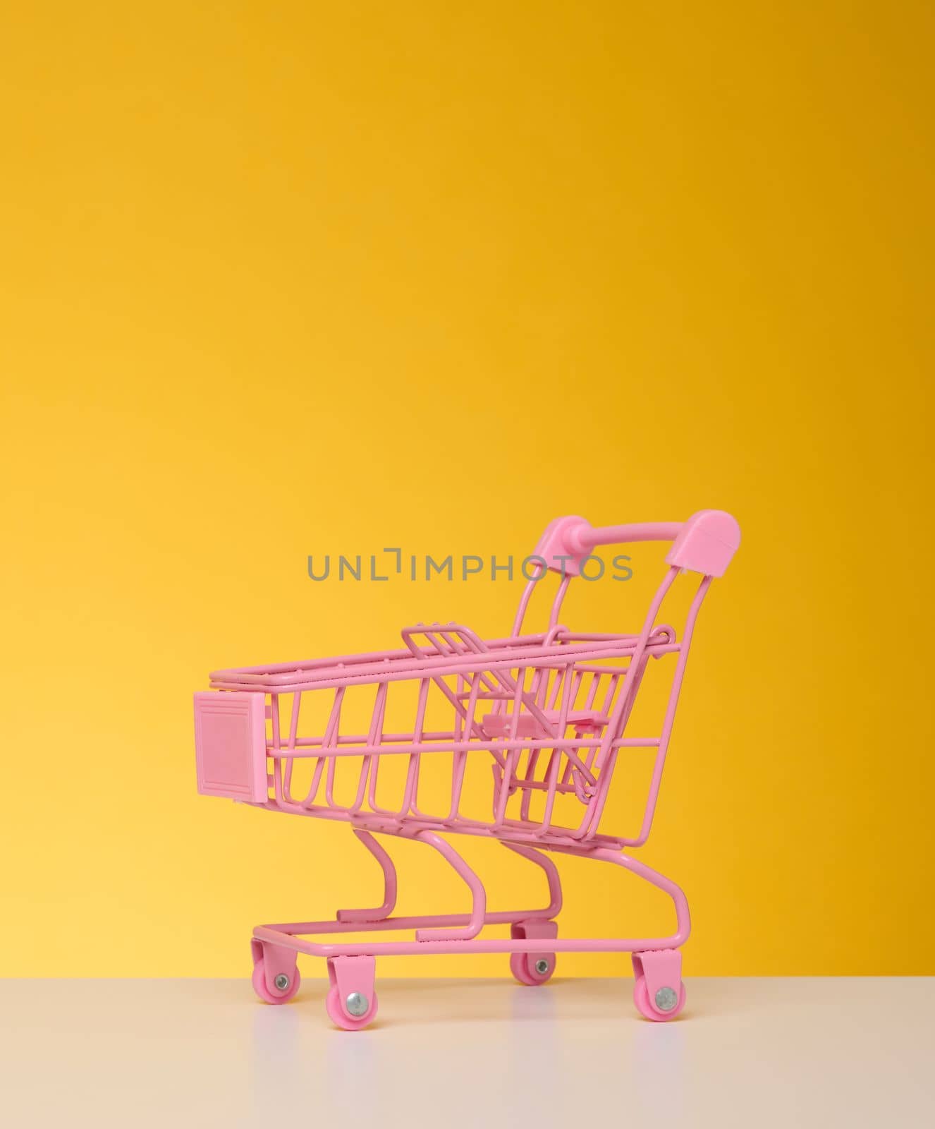 Empty miniature shopping cart on a blue background. Seasonal sale