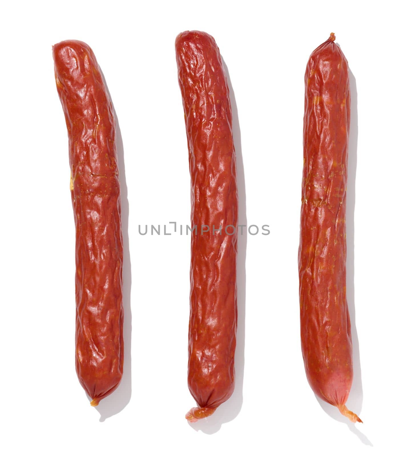 Small smoked sausages on a white isolated background, top view