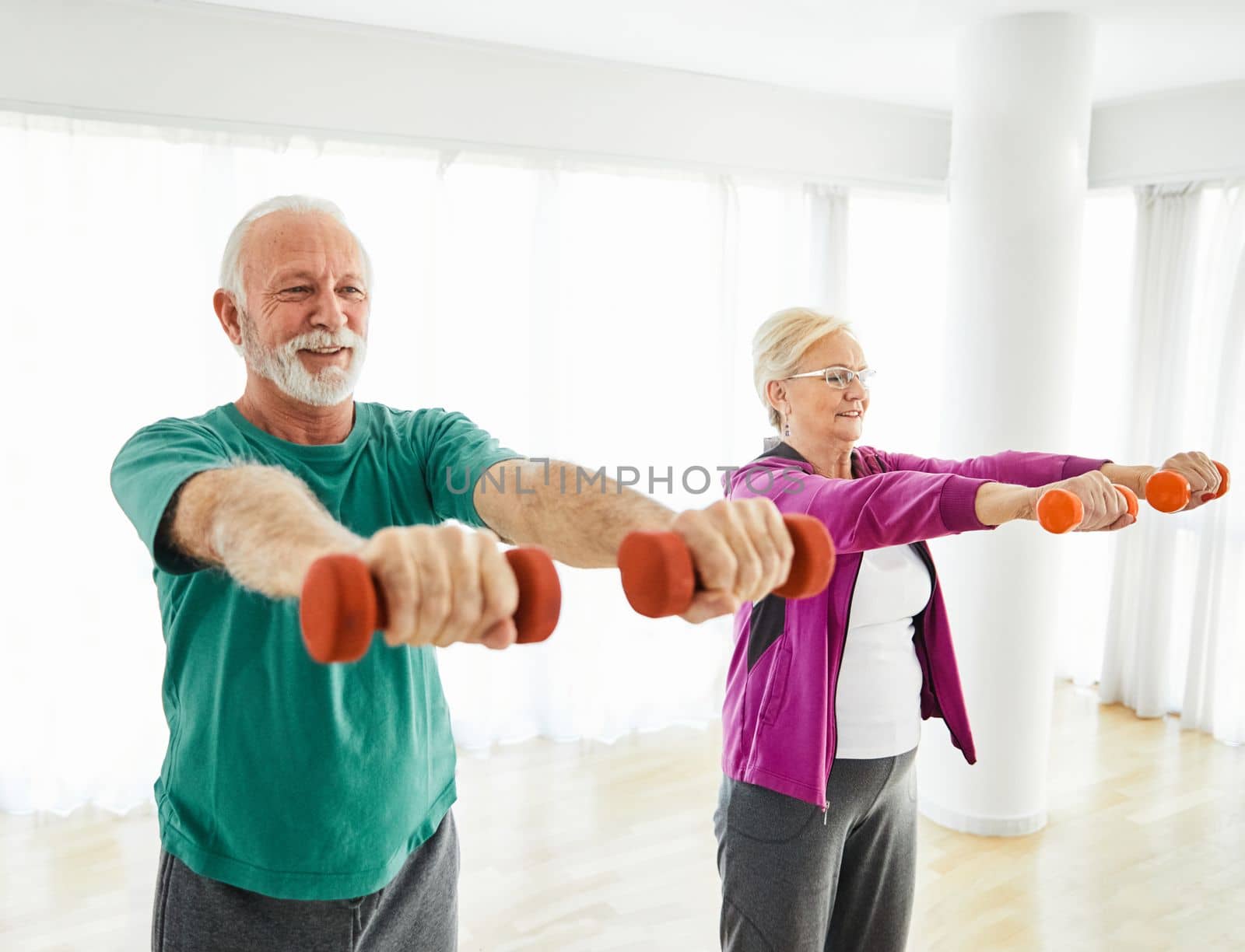 Senior couple exercise stretching and exercising with dumbbell lifting weigth at home health care