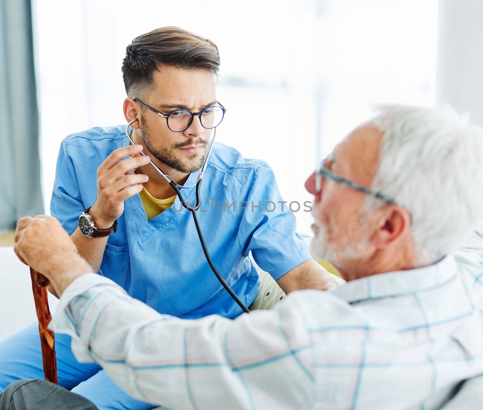 Doctor or nurse caregiver showing a tablet screen to senior man at home or nursing home