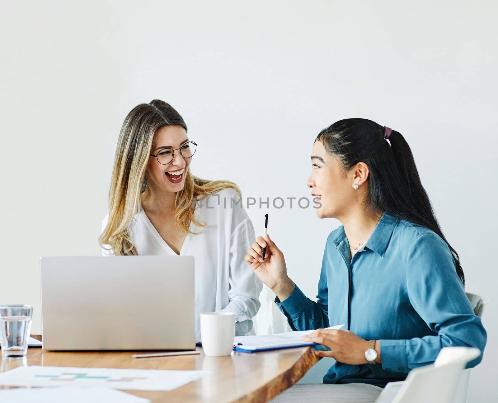 Portrait of a group of young businesswomen multiethnic working with laptop on desk and talking in a start up office