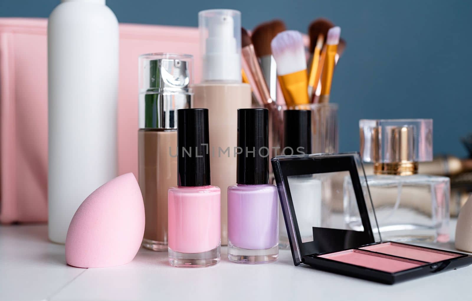closeup of feminine cosmetic products standing on dressing table by Desperada