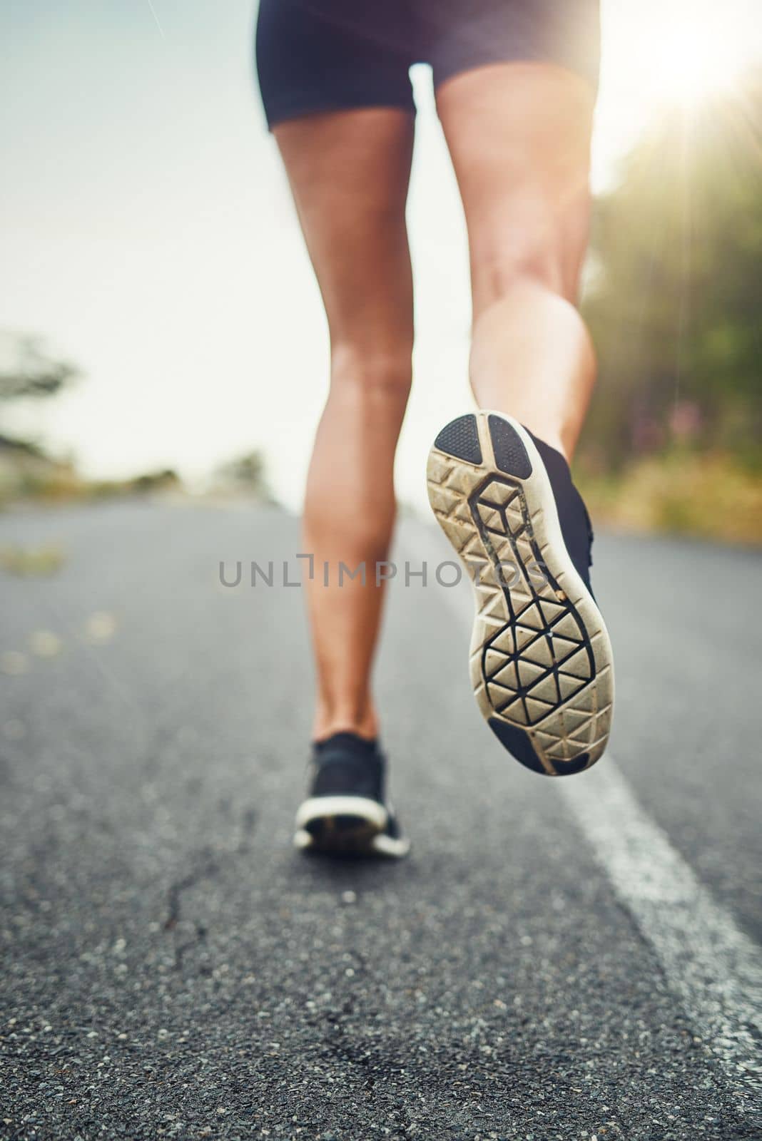 Start your day with a run. an unrecognizable woman training for a marathon outdoors. by YuriArcurs