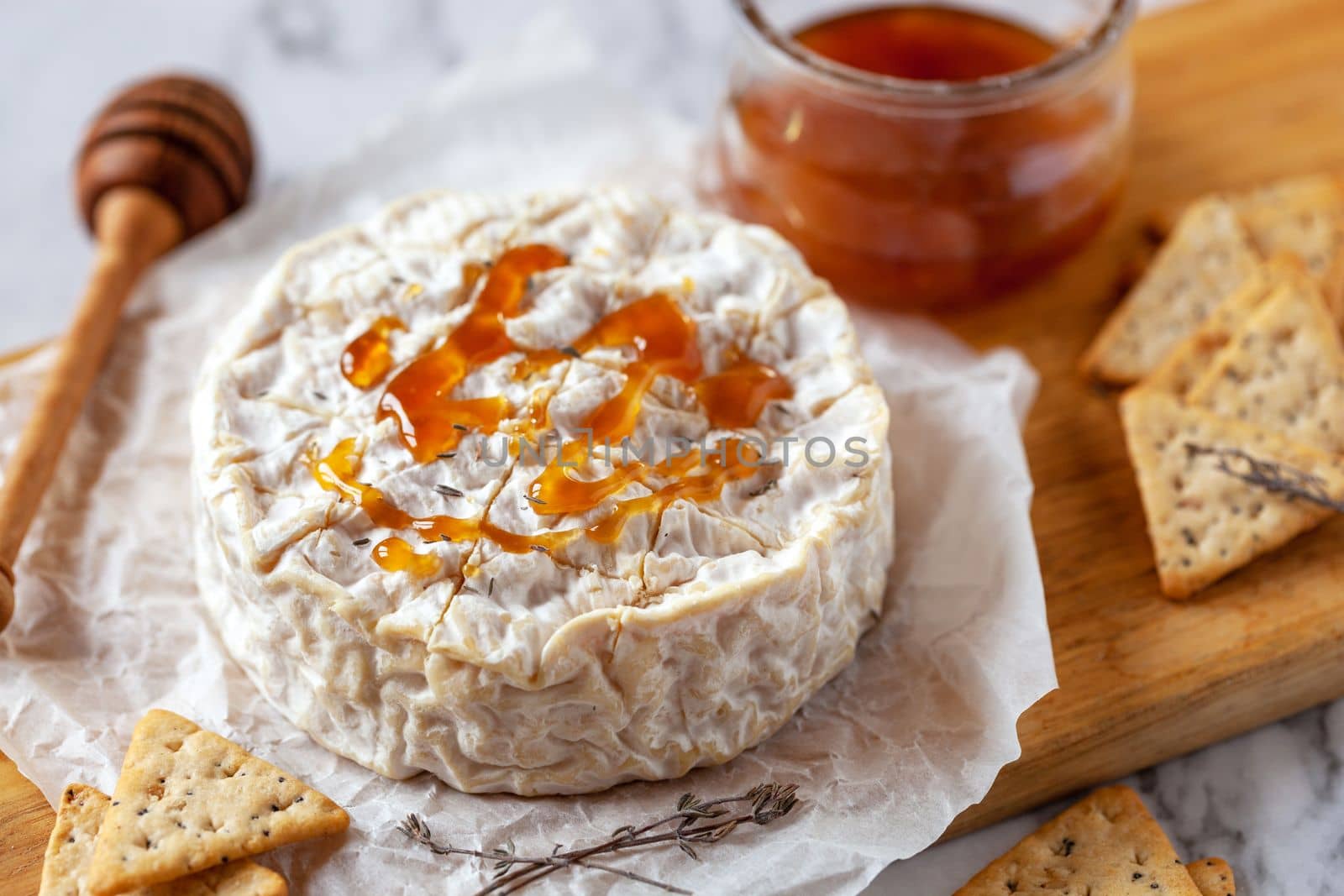 Camembert soft french cheese served with honey and crackers, top view by lanych