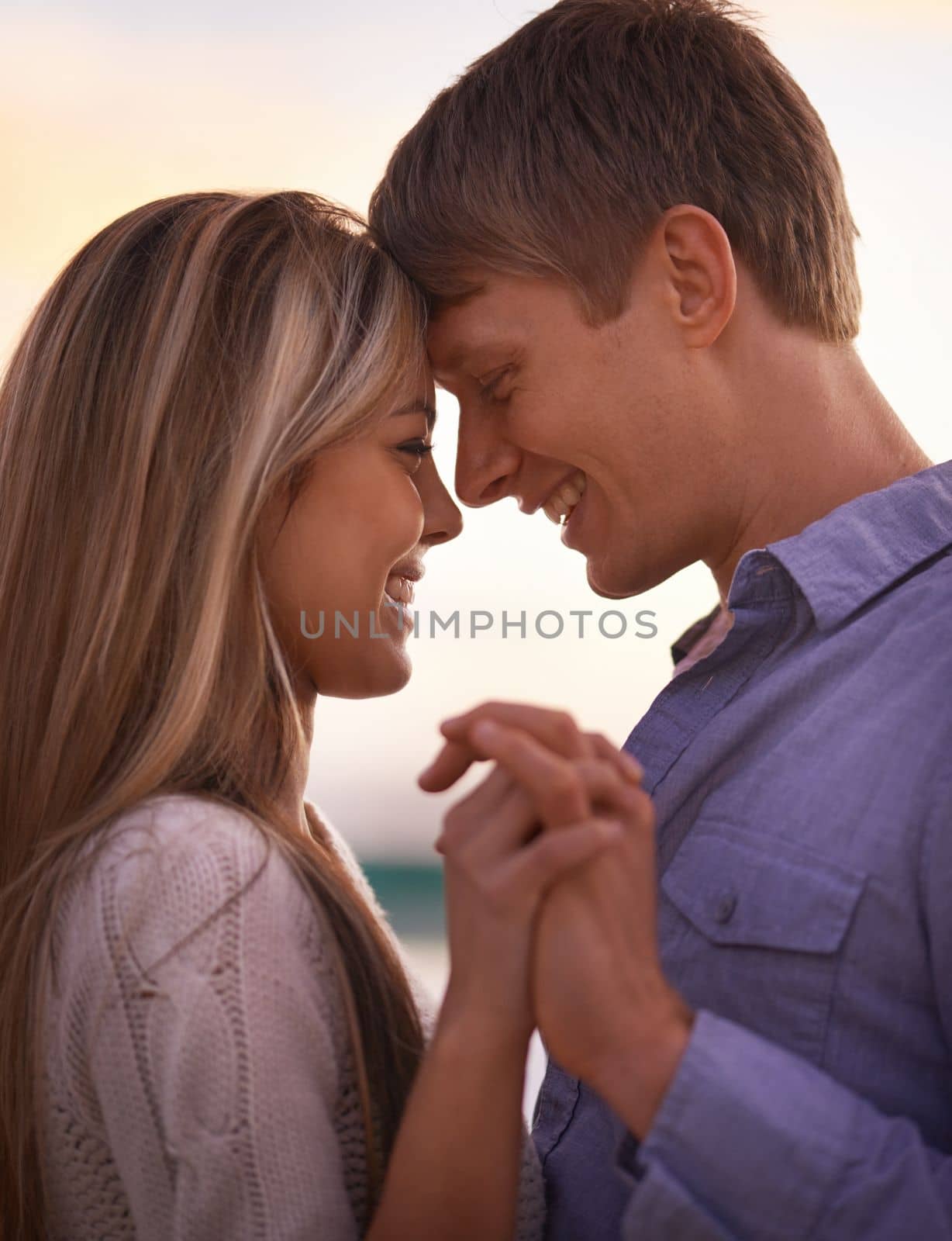 Our souls are intertwined. a young couple enjoying a romantic moment at sunset. by YuriArcurs