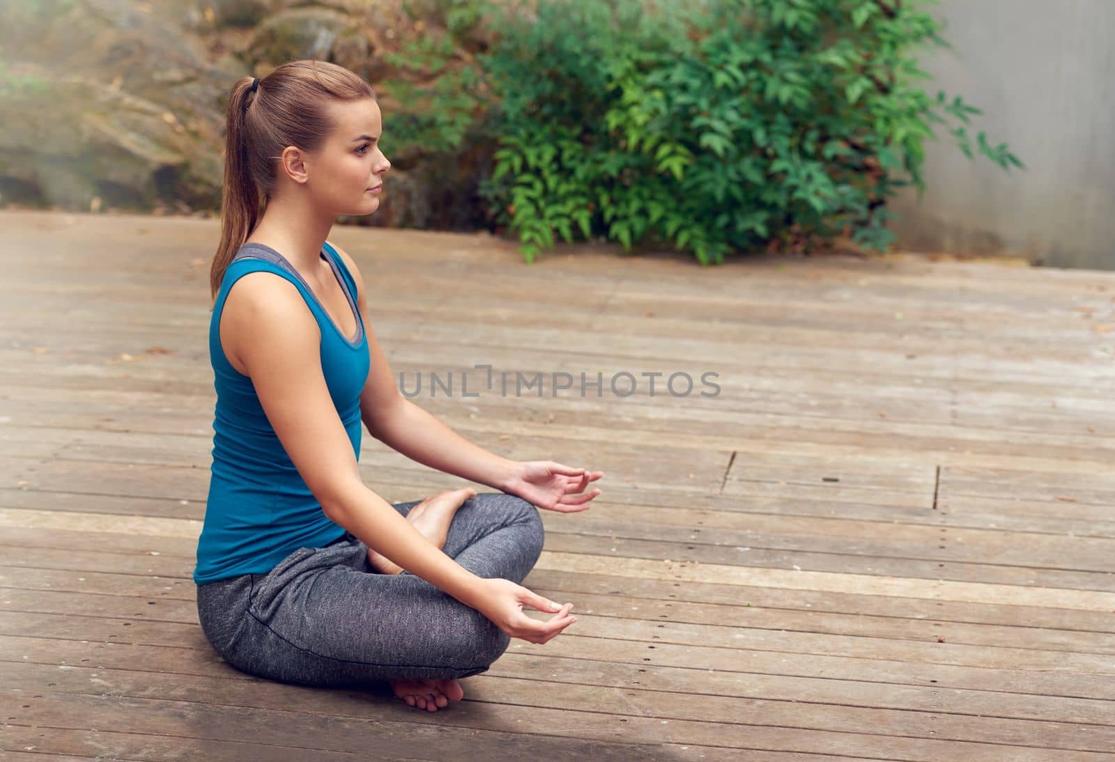 Yoga keeps her calm. a young woman practicing yoga outdoors. by YuriArcurs