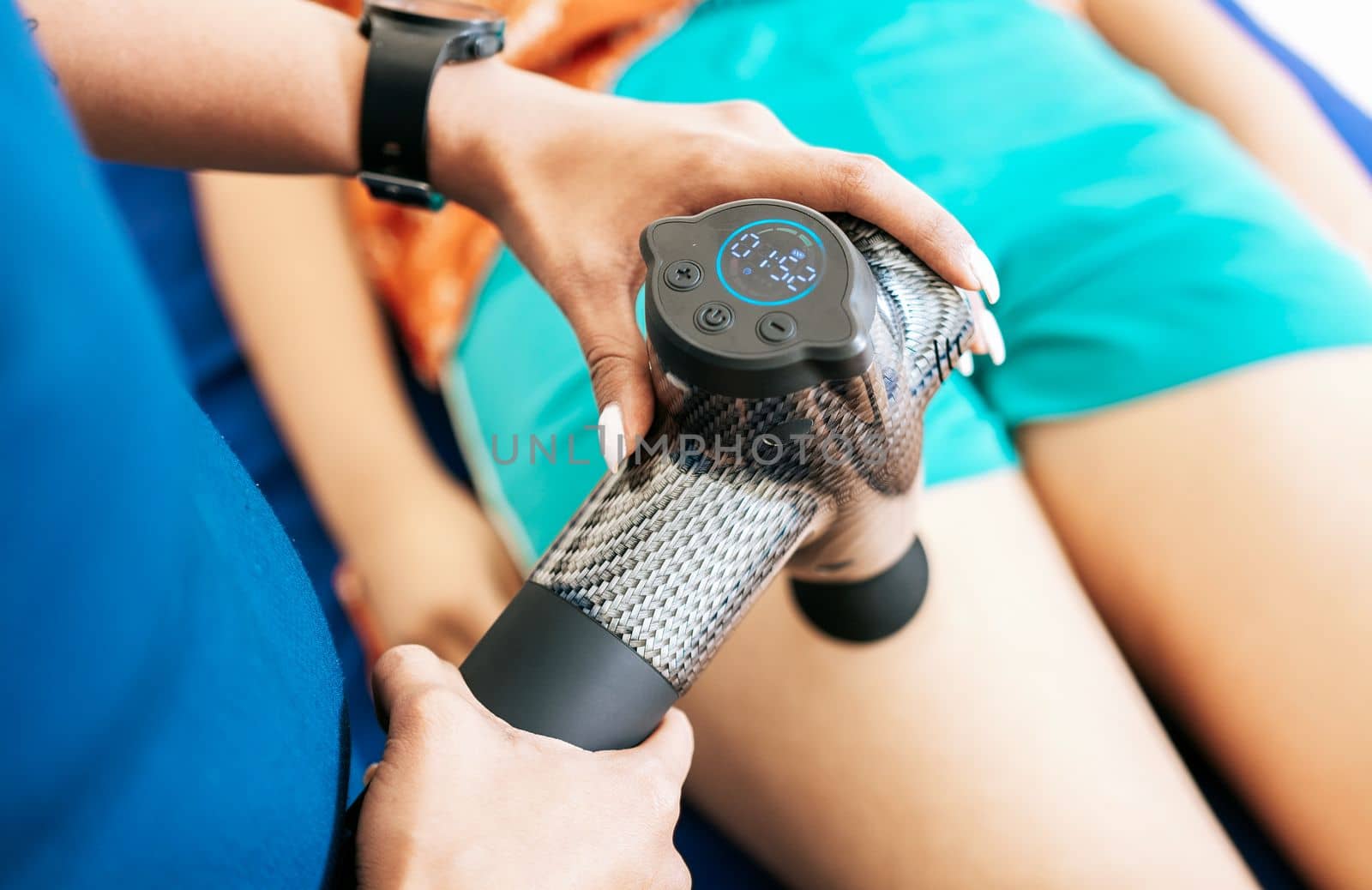 Physiotherapist using massage gun to relieve muscle pain, Percussion or vibration therapy. Physiotherapist using massage gun on patient. Chiropractor using massage gun on patient leg