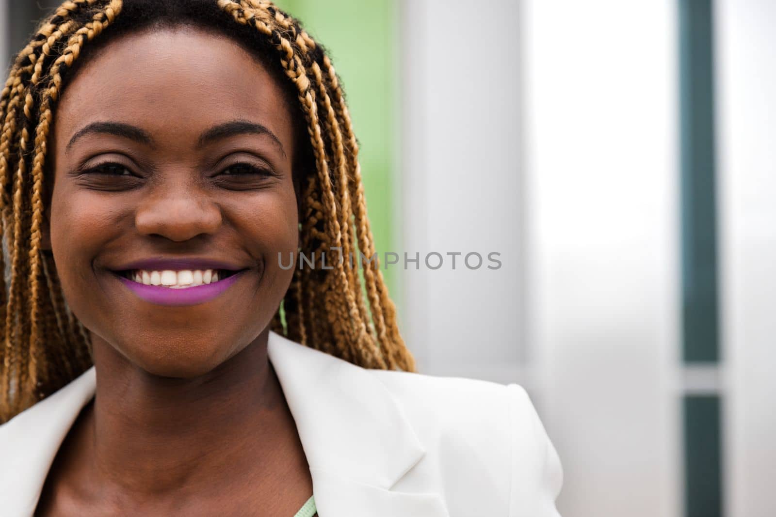 Portrait headshot of happy young African American woman with blond braided hair looking at camera. Copy space. Lifestyle.