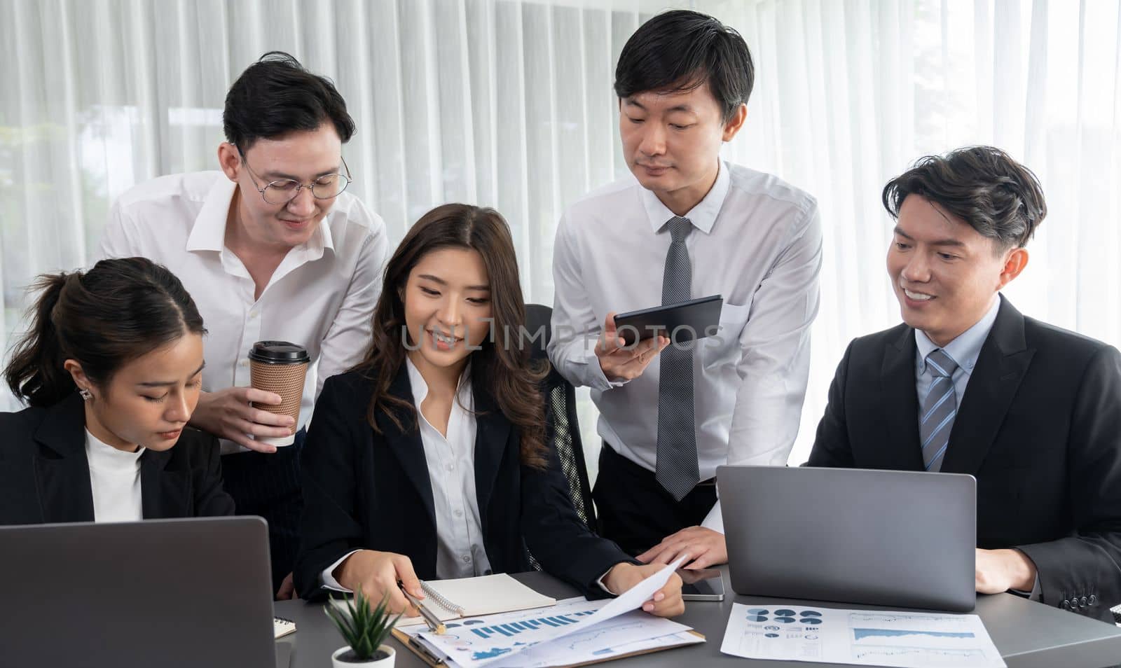 Harmony in office concept as business people analyzing dashboard paper together in workplace. Young colleagues give ideas at manager desk for discussion or strategy planning about project.
